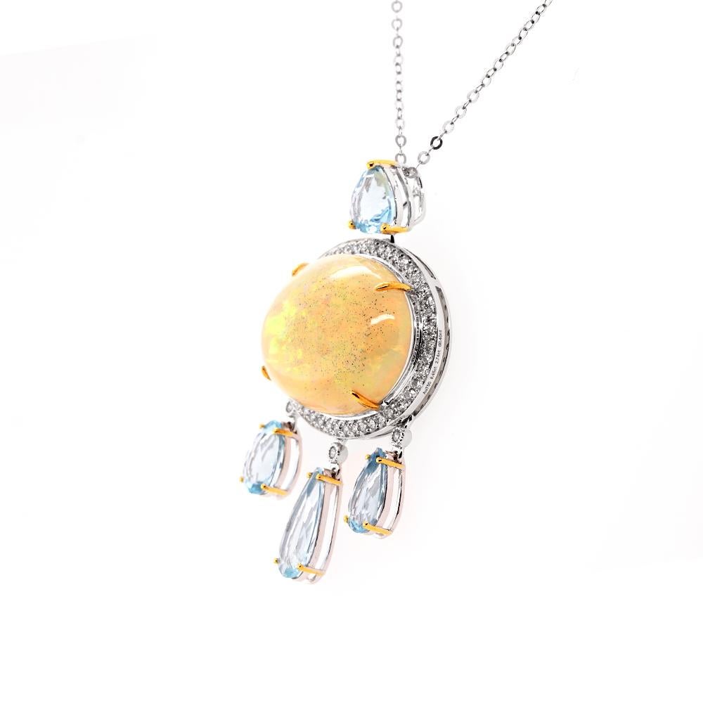 Indulge in the opulence of this two-tone 18ct gold pendant, a symphony of elegance and iridescent charm. Anchored by a pear-cut aquamarine in an 18ct gold bezel, the pendant exhibits an 8.45ct opal, ensconced in 18ct white gold and embraced by a