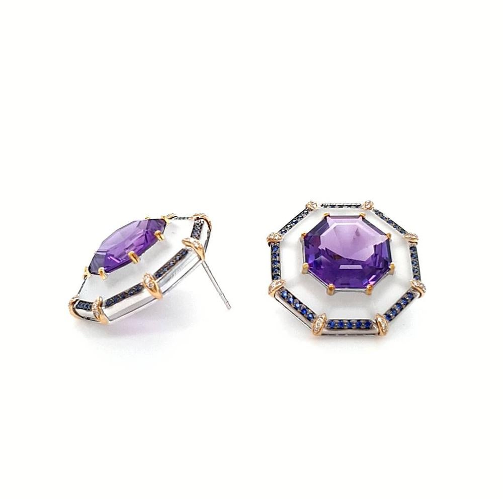 An exquisite pair of statement earrings, each masterfully crafted from 18ct white gold. Measuring 21mm in diameter, these striking octagon-shaped studs showcase a 4.83ct purple amethyst at their heart. Enveloped by a halo of matte-polished rock