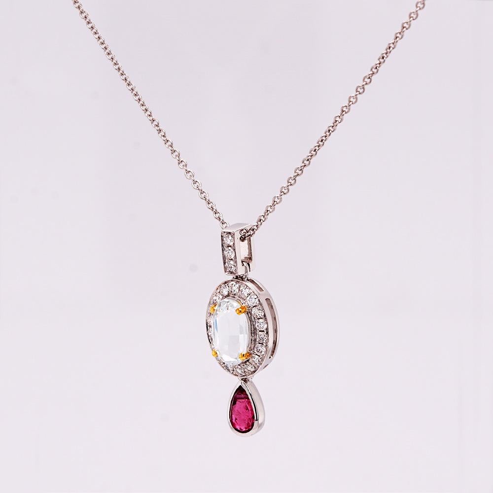 Mini in size and full of sparkle. This delicate pendant by Fei Liu is made in 18ct white gold, featuring a 0.48ct aquamarine embraced by a diamond-set bail and frame totalling 0.156ct. Suspended with a 0.26ct pear-cut ruby that adds a touch of