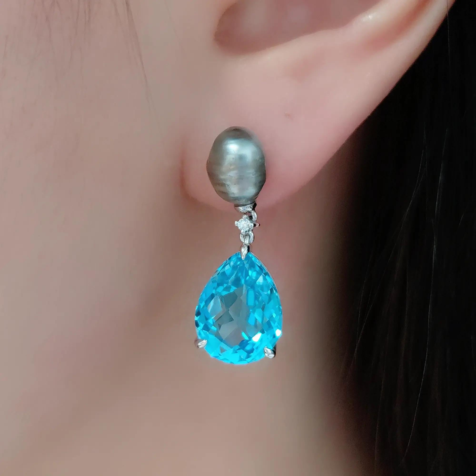 Una miscela armoniosa di brillantezza e bellezza organica, questi orecchini a goccia in platino presentano 5,53 carati di topazio blu sfaccettato - ogni gemma a goccia brilla con chiarezza cristallina e profondità oceanica. Sopra, perle barocche per