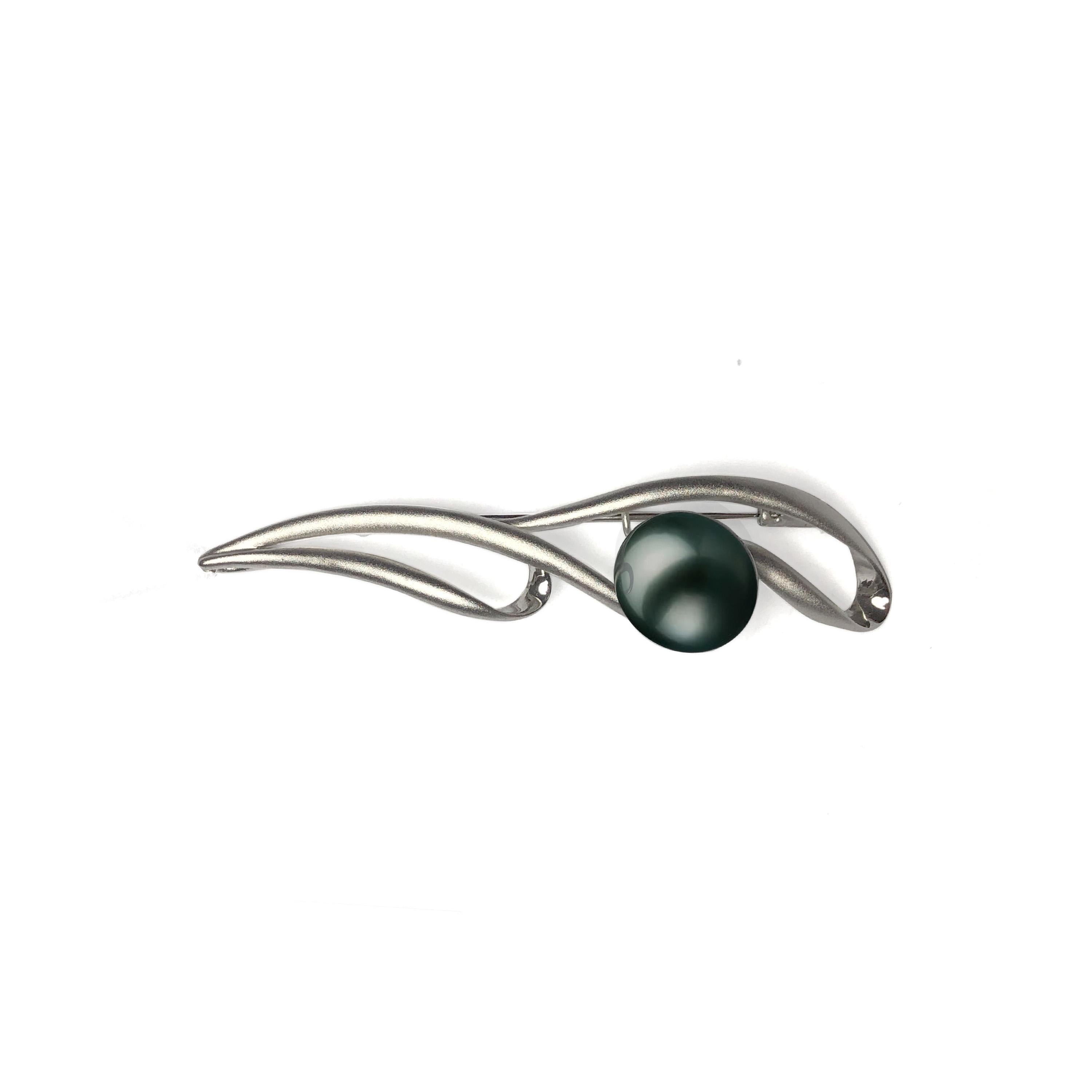 A versatile design with an East meets West fusion. The traditional black pearl rests assuredly atop the gentle waves of satin-textured sterling silver.

A vintage style brooch with a modern twist. Easily style to suit your occasion. The 16