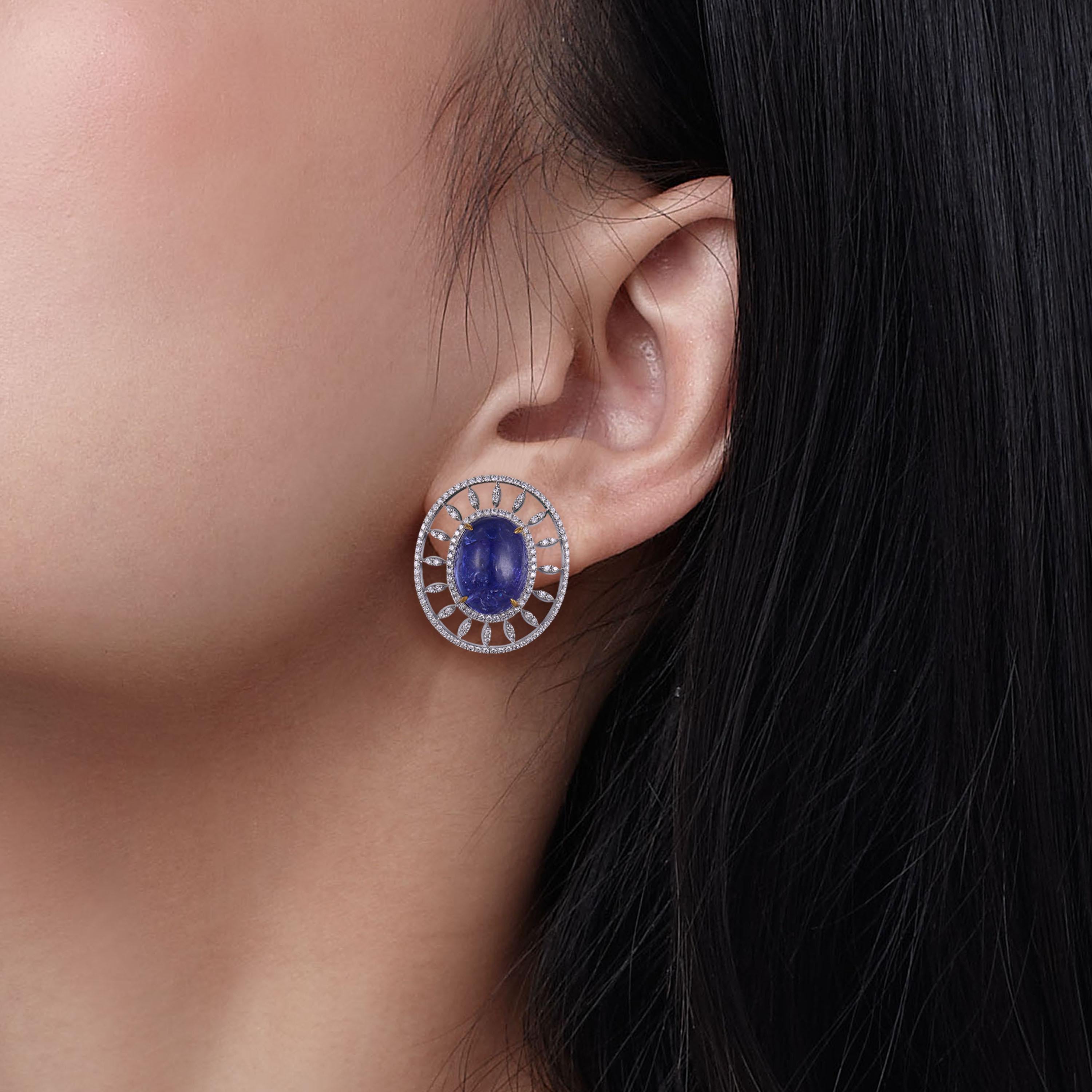 Limited edition tantalising tanzanite stud earrings by Fei Liu Fine Jewellery capturing the beauty of symmetry. It features natural tanzanite cabochon, each with an approx. weight of 12ct. Decorated with diamond halos. Expertly crafted from 18 karat