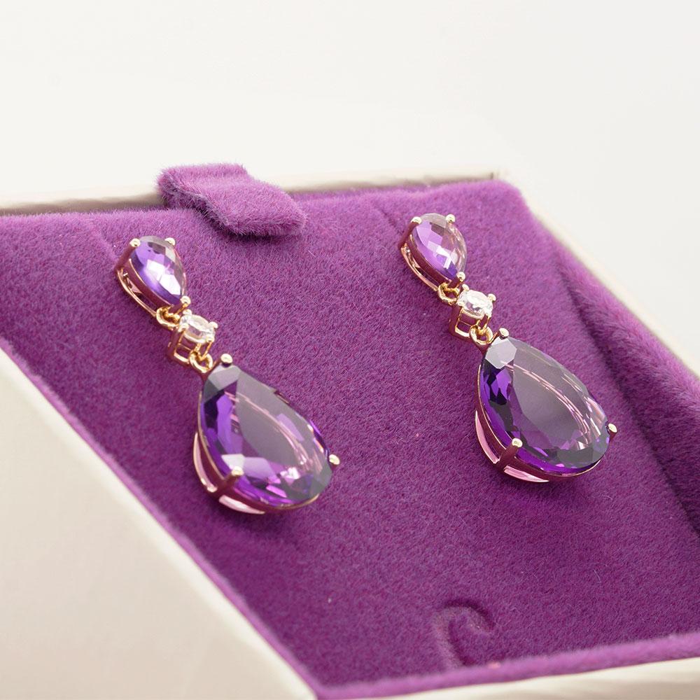 Add a pop of colour to your look with vibrant gems from Mother Nature. These drop earrings feature two purple amethysts, one pear cut and one briolette, interspersed with a dazzling diamond. Each gemstone harmoniously exhibits its beauty within a