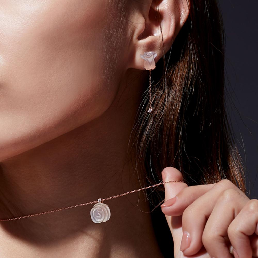 The Chalcedony Rose Necklace and Earrings Set, a limited edition, features exquisitely hand-carved ice chalcedony petals, complemented by sparkling diamonds. Set in 18ct rose gold, each piece exudes timeless elegance, while the chain is crafted in