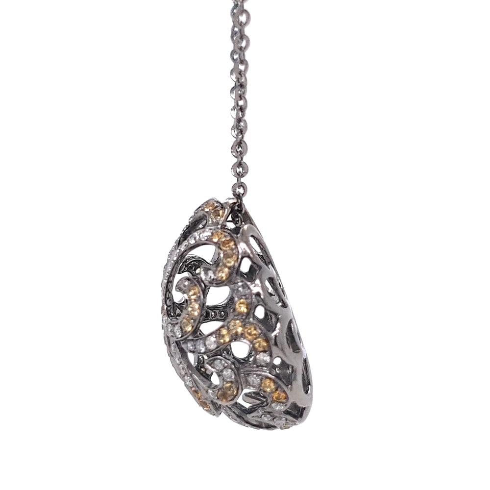 The Whispering Filigree Egg Pendant blends timeless elegance with intricate craftsmanship. Set in black rhodium-plated 18ct white gold, the openwork egg design is embellished with glistening citrines and sparkling diamonds. Whether you prefer soft