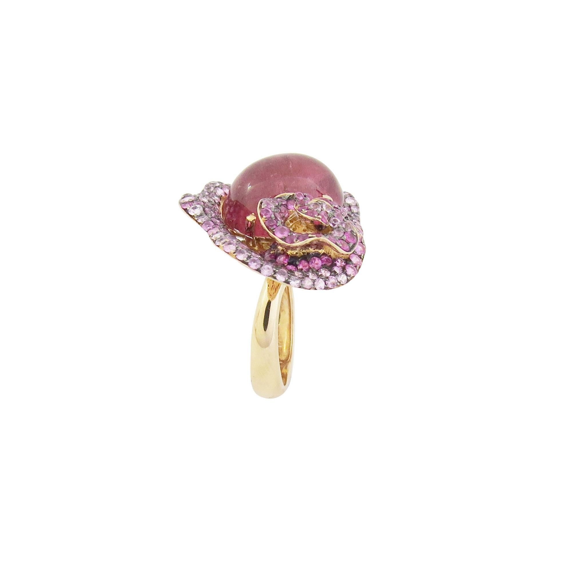 Description:
Fei Liu one-off ring with 12.32ct rubellite cabochon and 2.52ct pink sapphires, set in 18ct rose gold.

Ring size: M (UK) / 6 1/2 (US)

Inspiration:
Capturing the natural beauty of the flowers. From unearthing to blossom; unfurling its