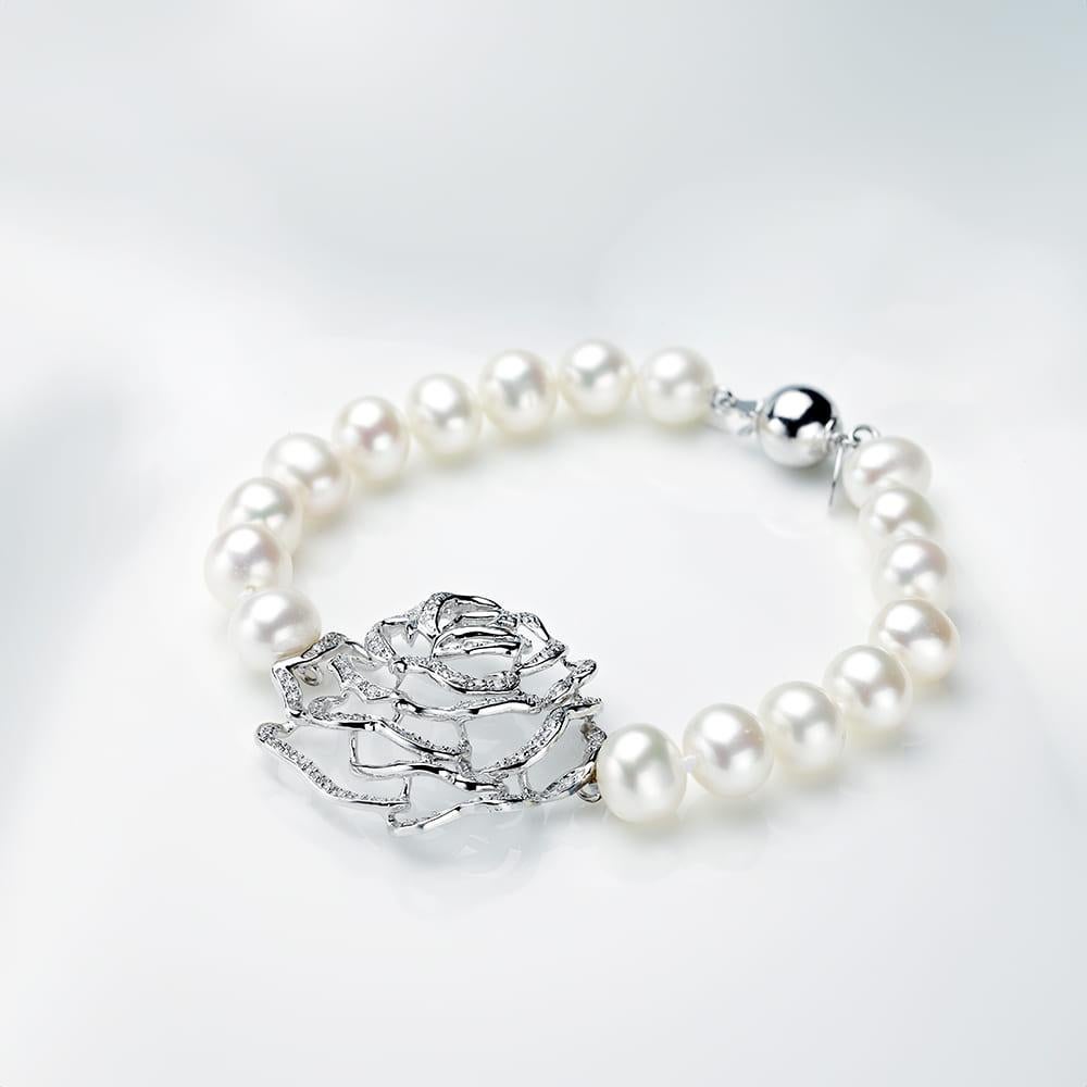 The Rose Pearl Bracelet is a captivating piece that exudes both elegance and uniqueness. Measuring 7.5 inches in length, this bracelet showcases a striking rose centrepiece, embellished with glistening gemstones that catch the light beautifully.