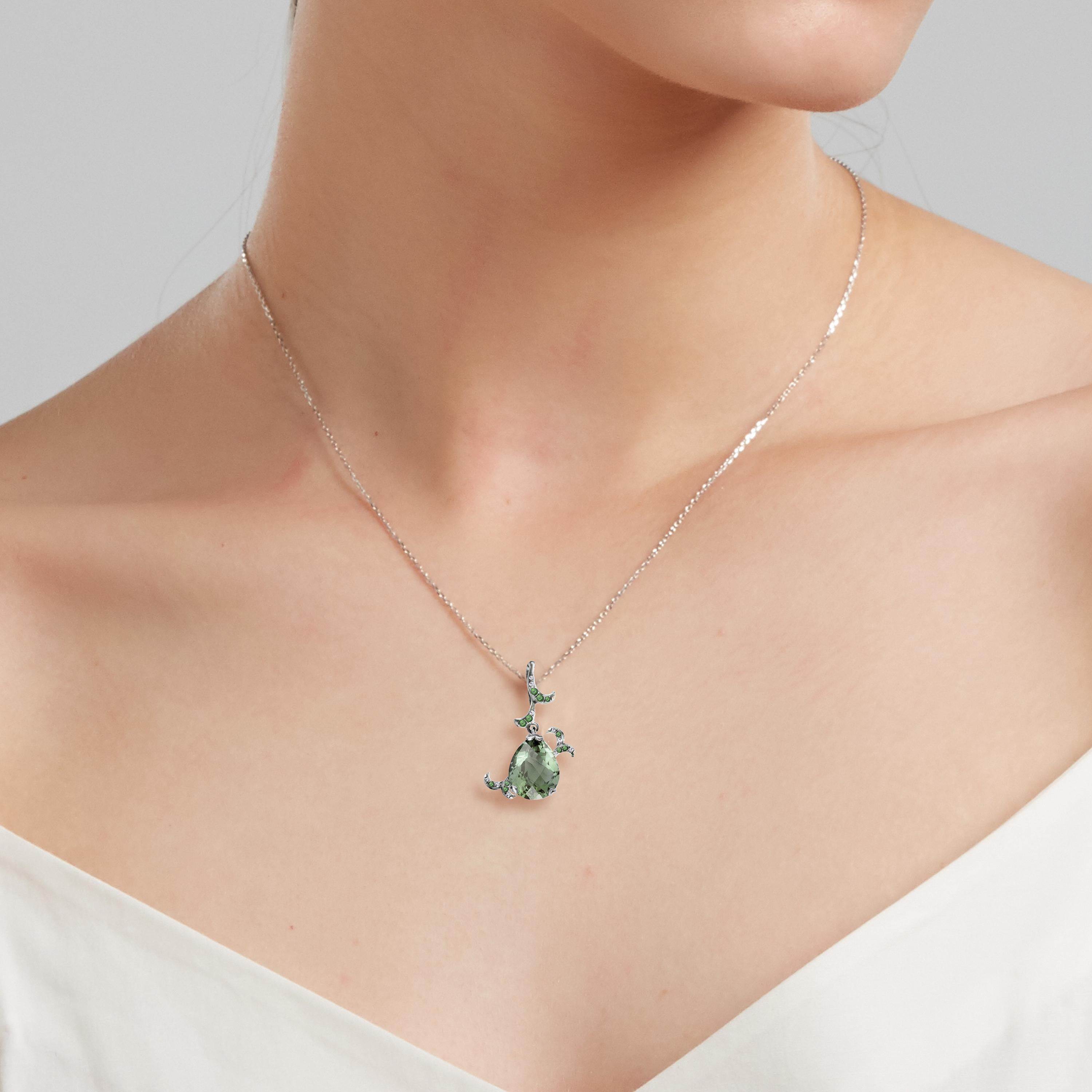 Description:
Whispering short pendant with curl detail featuring a 4.5ct green amethyst, 0.05ct diamonds and 0.09ct green garnets. Set in high polish black rhodium on 18ct white gold. Chain is 16 inches.

Inspiration:
Emulating femininity and