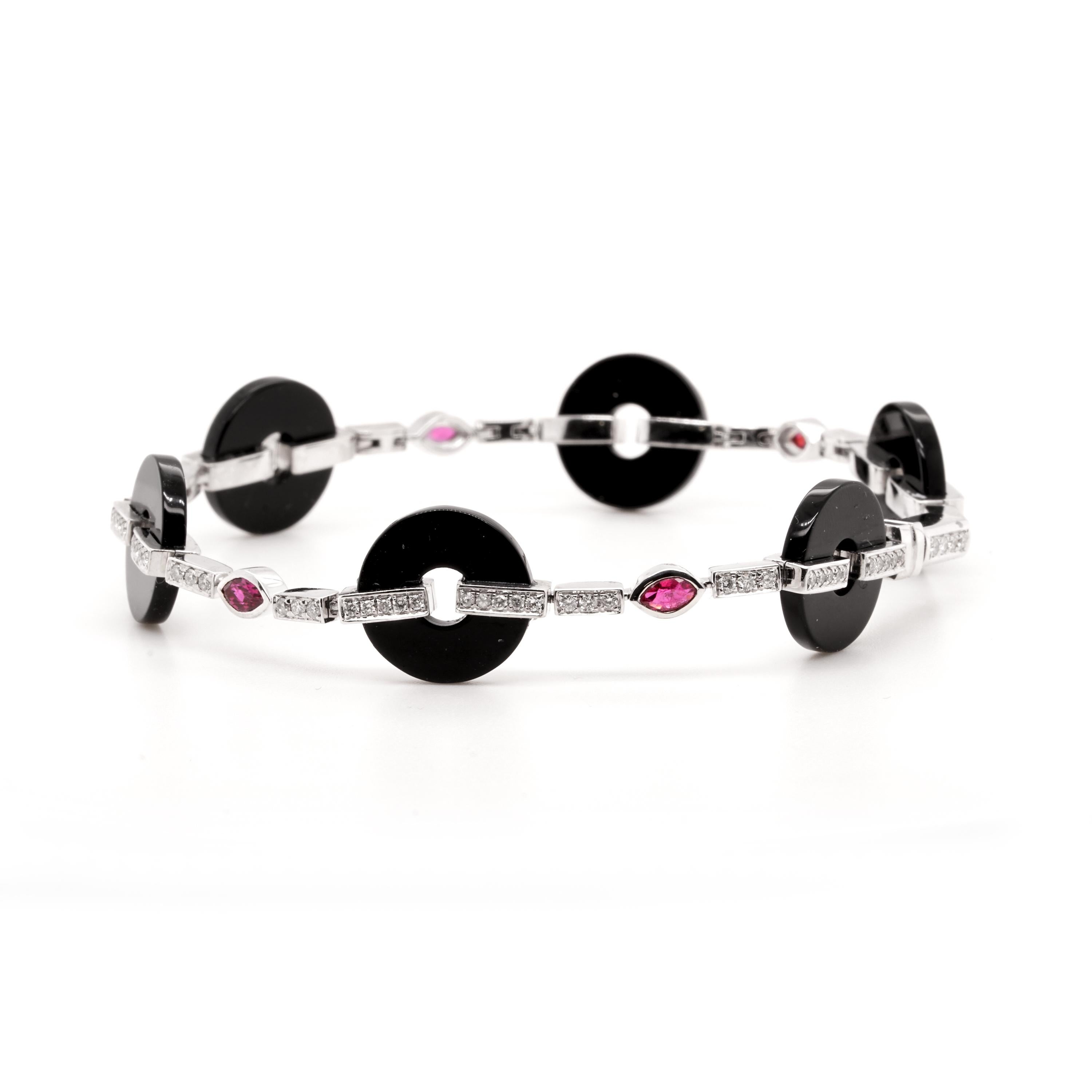 Description:
Sleek geometric lines and beautiful colour contrast. An art deco bracelet comprising circular onyx weighing a total of 14.2ct with articulated 18ct white gold embellished with diamonds and marquise cut rubies.

- Stone weights: onyx =