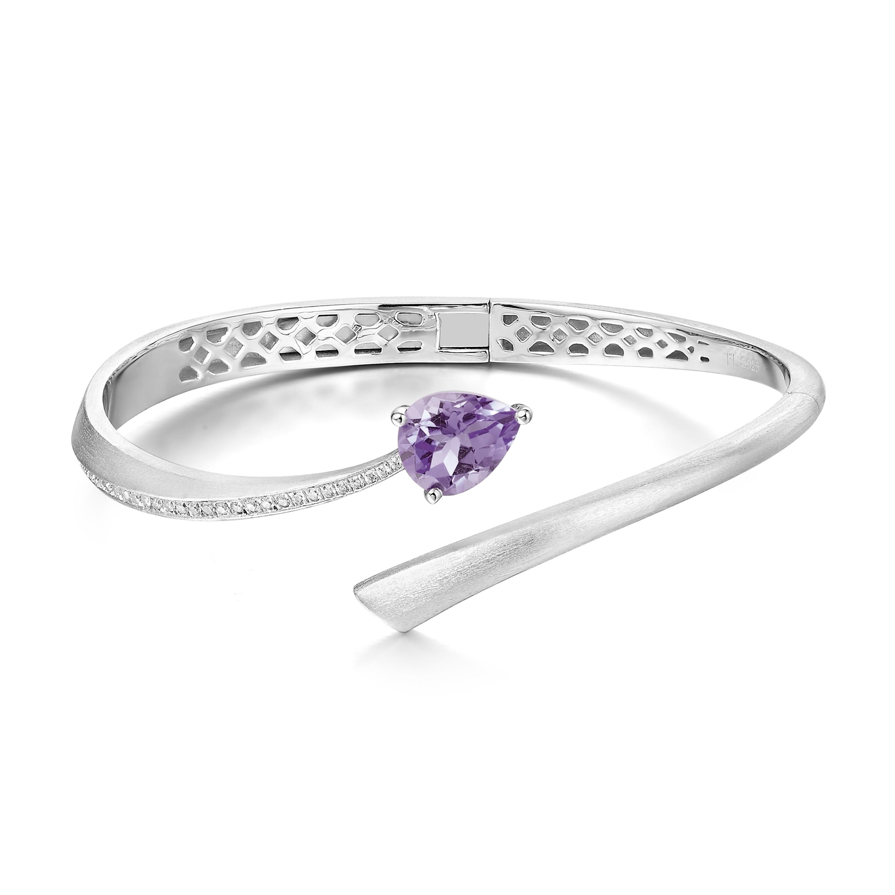 Description:
Shooting Star bangle with pear cut purple amethyst and Hearts and Arrows* white cubic zirconia, set in brushed polished white rhodium on sterling silver.

Inner diameter (LxW): small/medium = 56mm x 60 mm, large = 60mm x 65mm

*Hearts