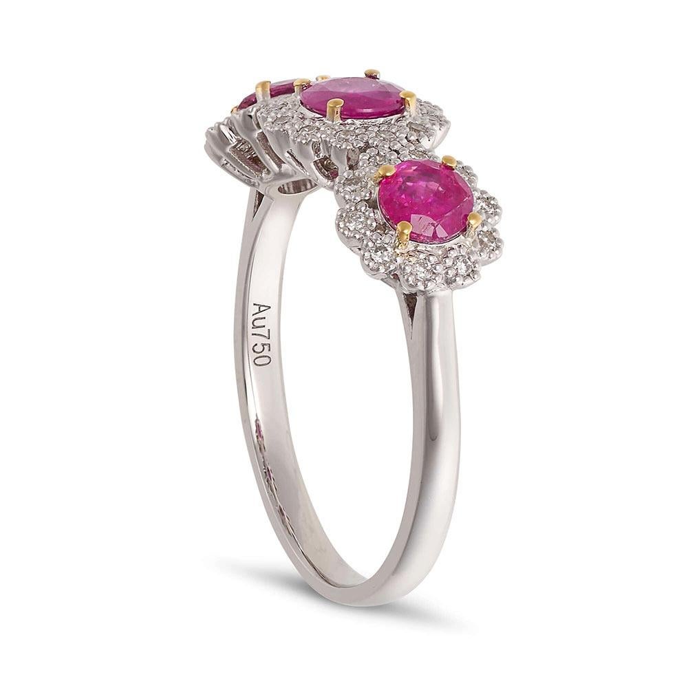 A stunning 18ct white gold trilogy ring (also known as three stone ring) featuring three ravishing rubies with a total weight of 1.11ct, each delicately framed with shimmering brilliant diamonds.

- Diamonds 0.15ct
- Size: leading edge N1/2 (UK) / 7