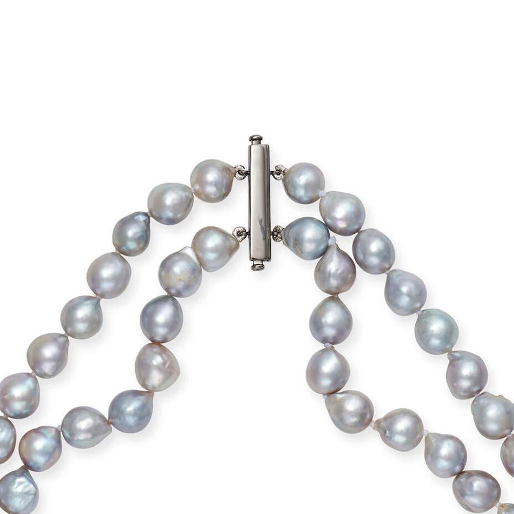 Un exquis collier de perles à deux brins de 16 pouces, témoin de l'élégance royale intemporelle. Composé de perles baroques grises naturelles, d'une taille d'environ 9 mm chacune, ce collier respire la sophistication grâce à ses formes uniques et