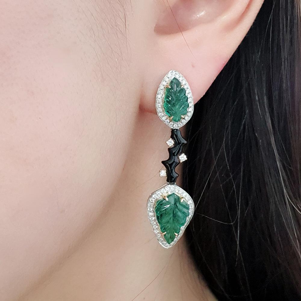 A breathtaking pair of earrings by renowned designer Fei Liu, exquisitely crafted in 18ct white gold with delicate yellow gold-plated accented claws. Showcasing vibrant Zambian emeralds, sleek onyx, and dazzling diamonds, this elegant design