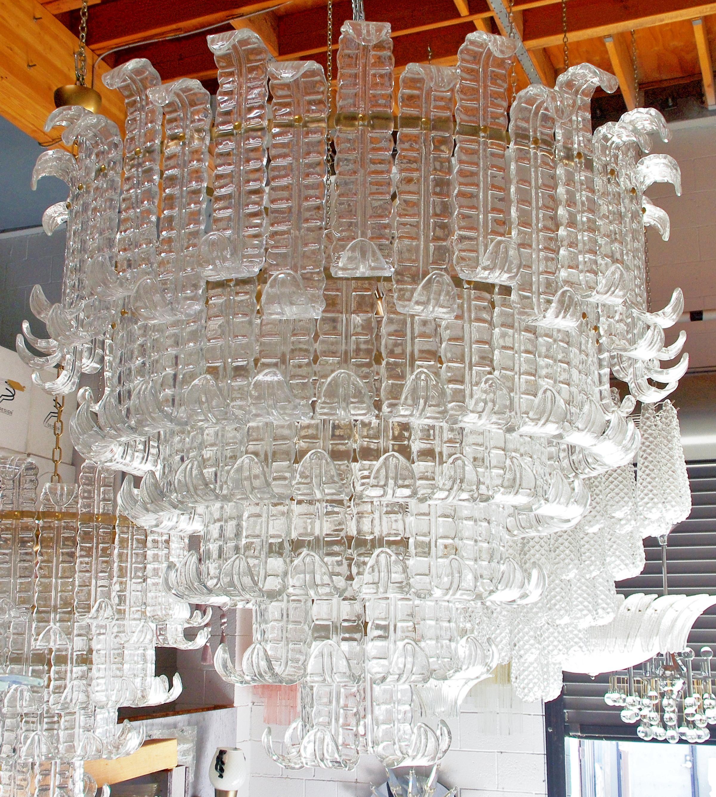 Lampadario italiano con sei livelli di vetri trasparenti soffiati a mano di Murano Felci montati su una struttura in metallo con finitura bronzata, di Fabio Ltd / Made in Italy
22 luci, tipo E26 o E27, max 60W ciascuna
Misure: Diametro: 43,5