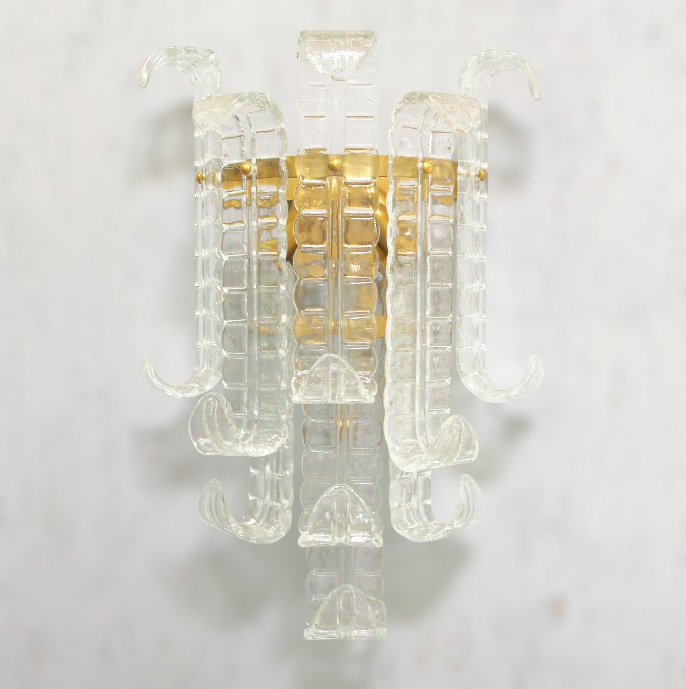 Aplique italiano con cristales transparentes soplados a mano de helecho de Murano Felci, montado en una estructura metálica con acabado bronceado, por Fabio Ltd / Made in Italy
2 luces / tipo E12 o E14 / máx. 40W cada una
Medidas: Alto 23,5