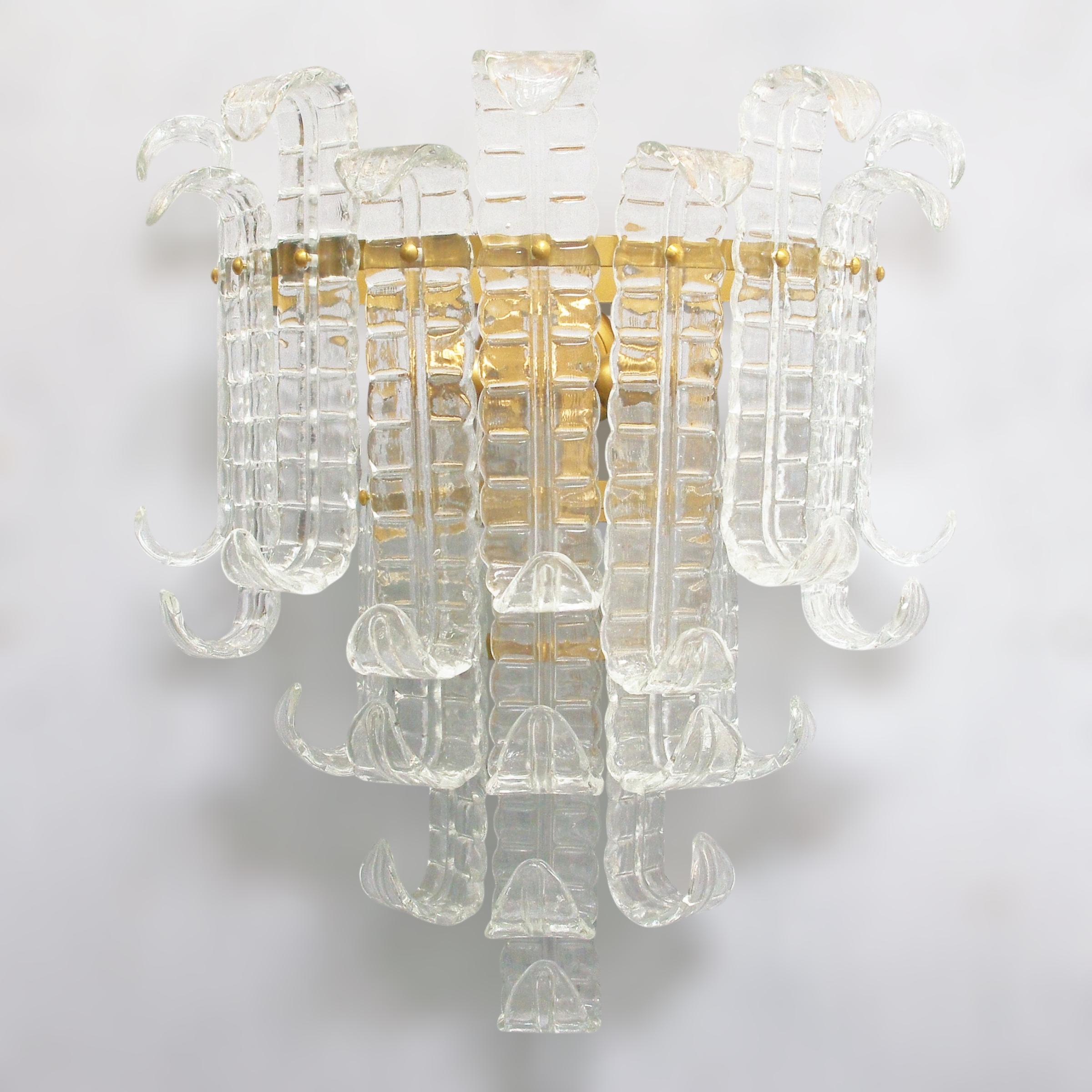 Aplique italiano con cristales transparentes soplados a mano de helecho de Murano Felci, montado en una estructura metálica con acabado bronceado, por Fabio Ltd / Made in Italy
3 luces / tipo E12 o E14 / máx. 40W cada una
Medidas: Alto 27,5