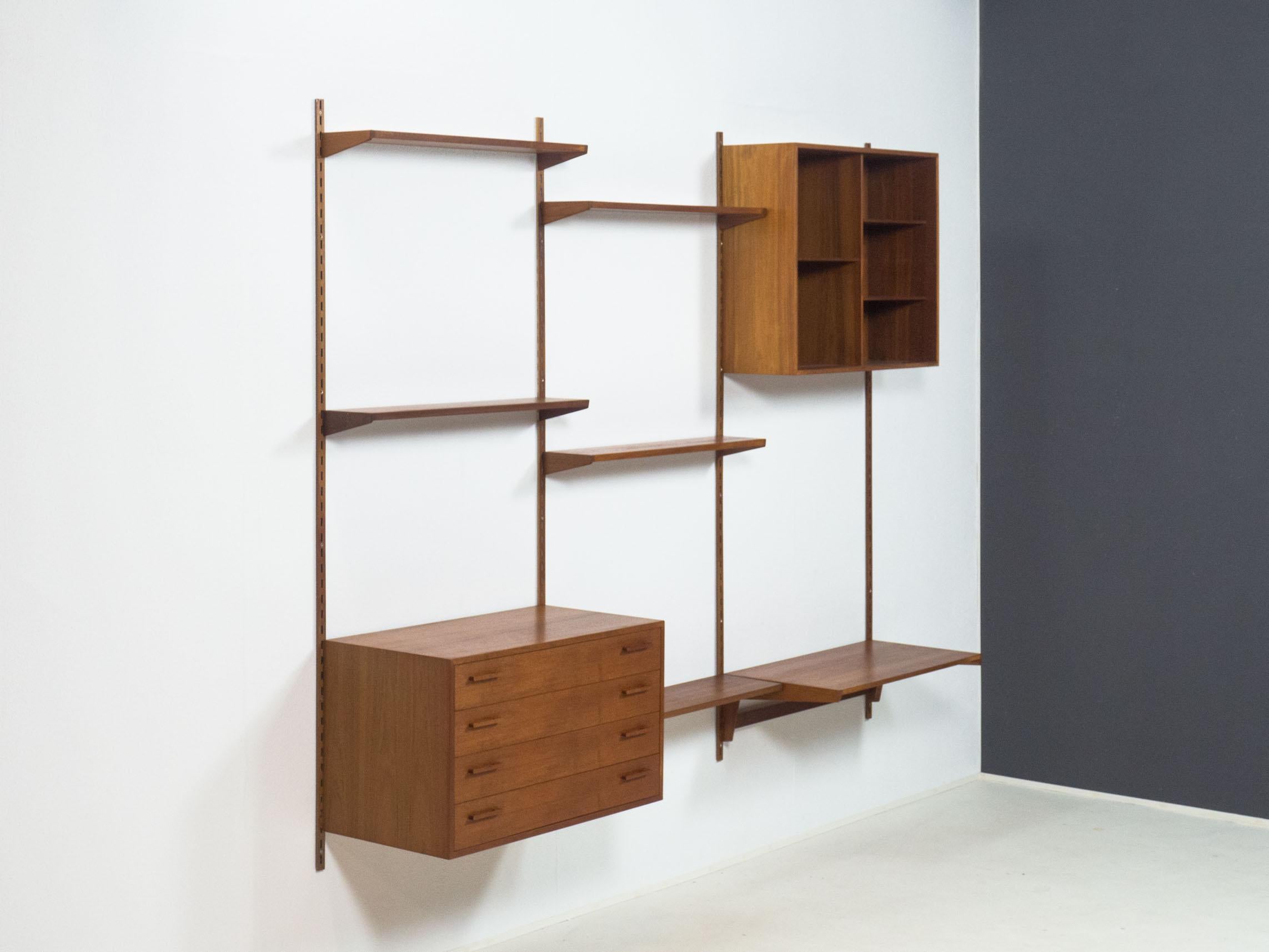 Wall unit designed by Kai Kristiansen for Feldballes Møbelfabrik, Denmark in the 1960s.

This wall unit is completely veneered in teak, including the wall rails. The sides of the shelves and the drawer handles are made of solid teak.

The unit