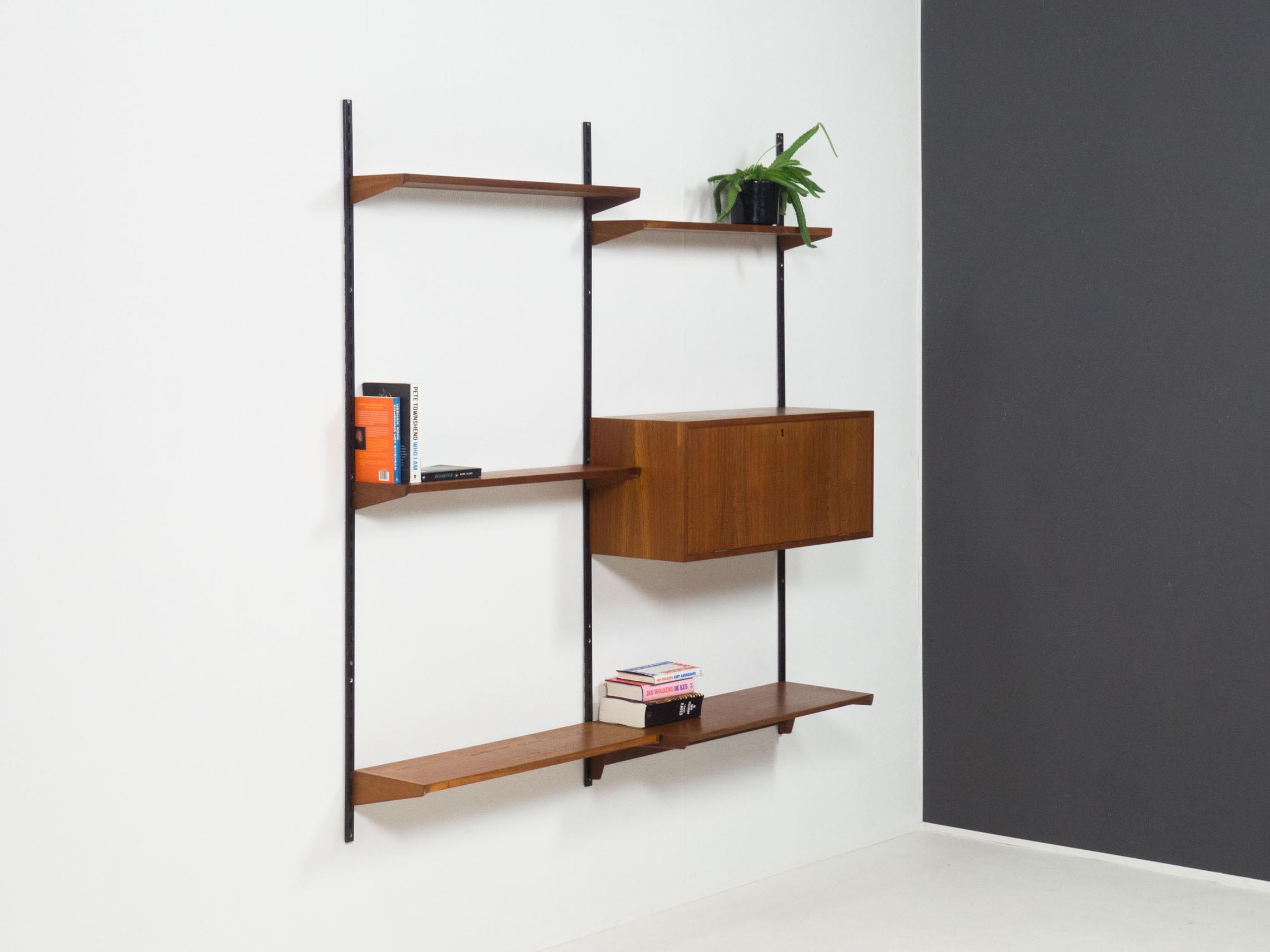 Wall unit designed by Kai Kristiansen for Feldballes Møbelfabrik, Denmark in the 1960s.

This wall unit is completely veneered in teak, with brown coated wall rails. The sides of the shelves are made of solid teak.

The unit is in very good