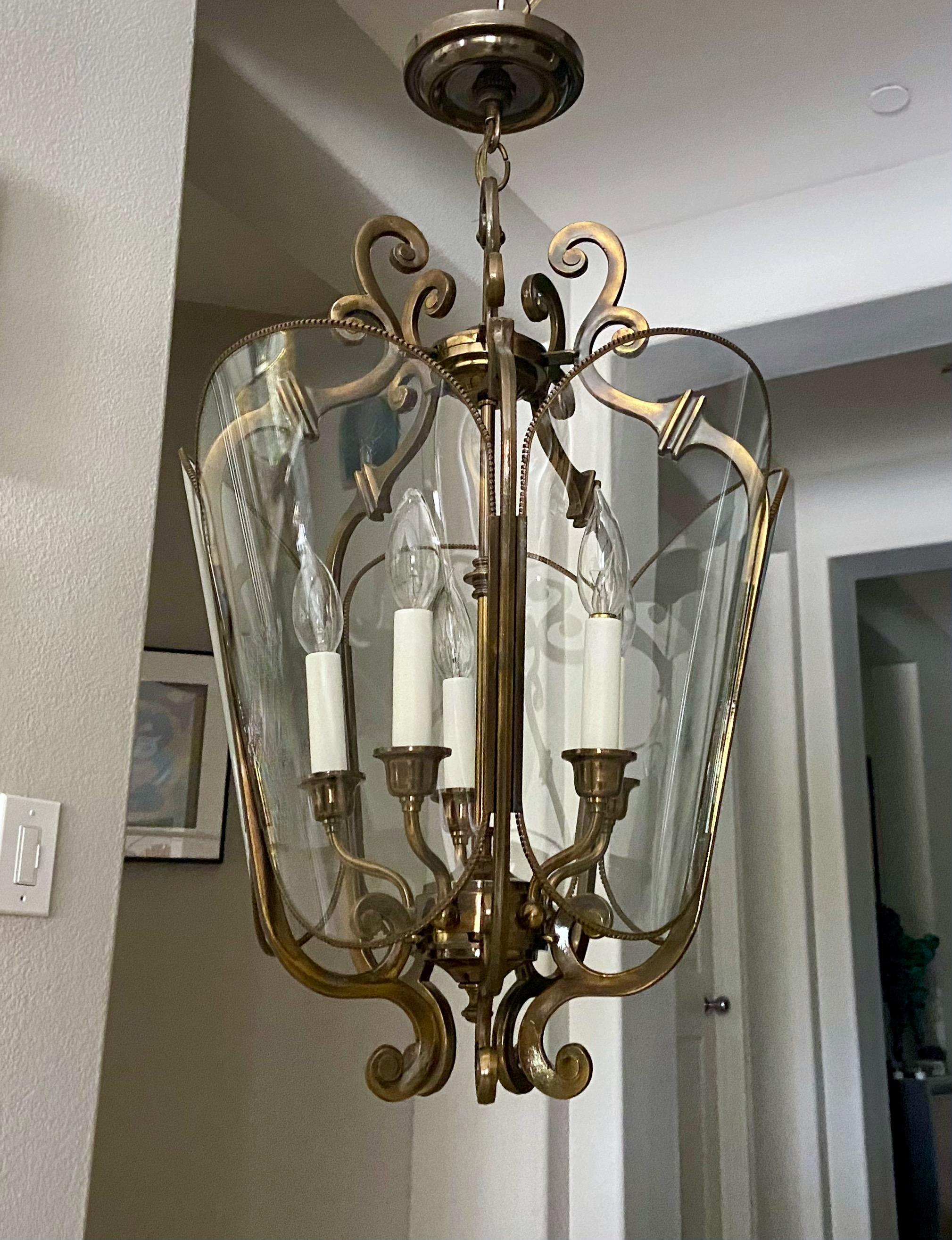 Solid antiqued brass hall lantern or pendant with removable glass panels and five-light arm light cluster, by Feldman Lighting Los Angeles. 
28