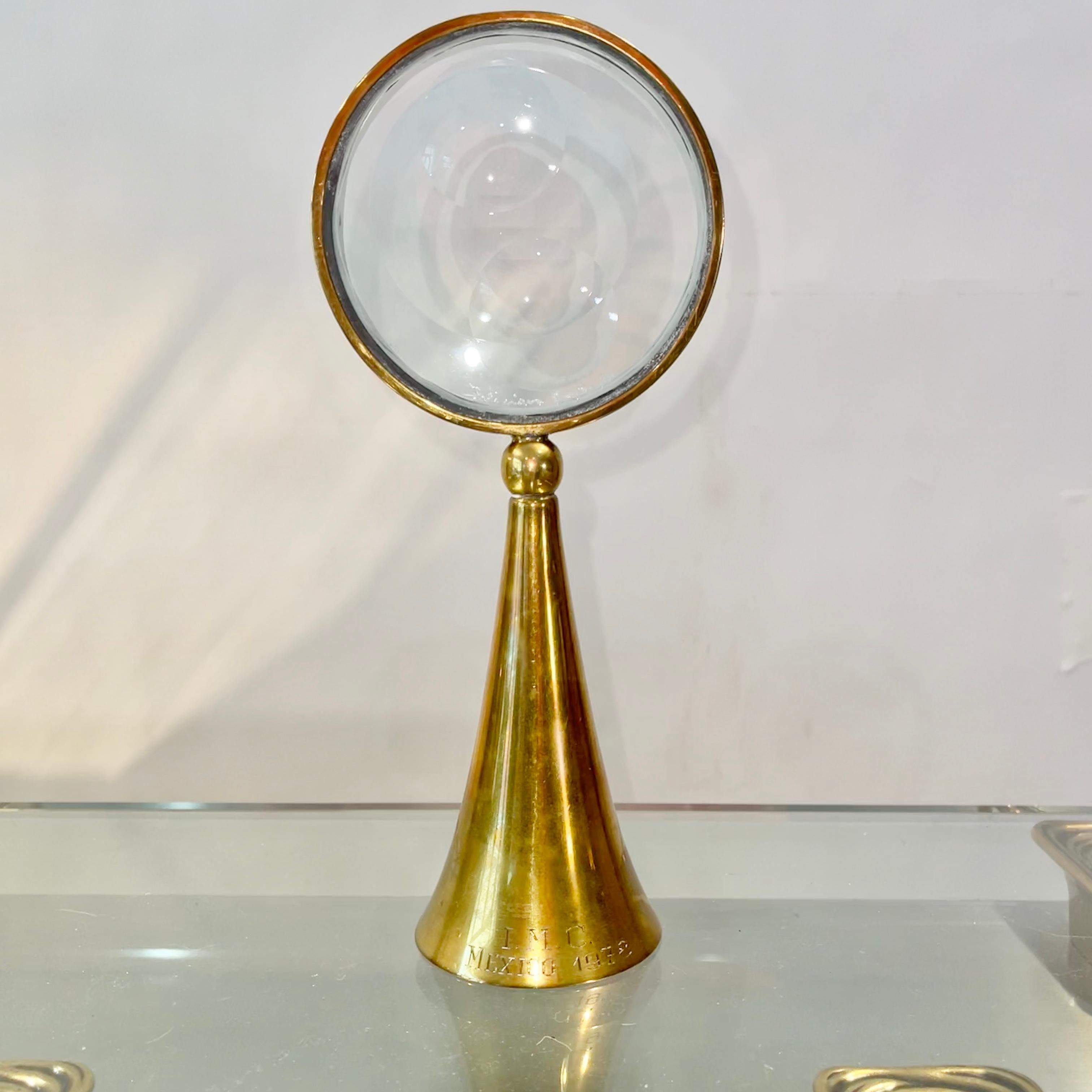 Feliciano Bejar (Mexico, 1920-2007) small brass Magiscope sculpture. 
Flared weighted conical base holds a circular brass frame and glass disc with optical ground concave dimples. 
Signed and dated 