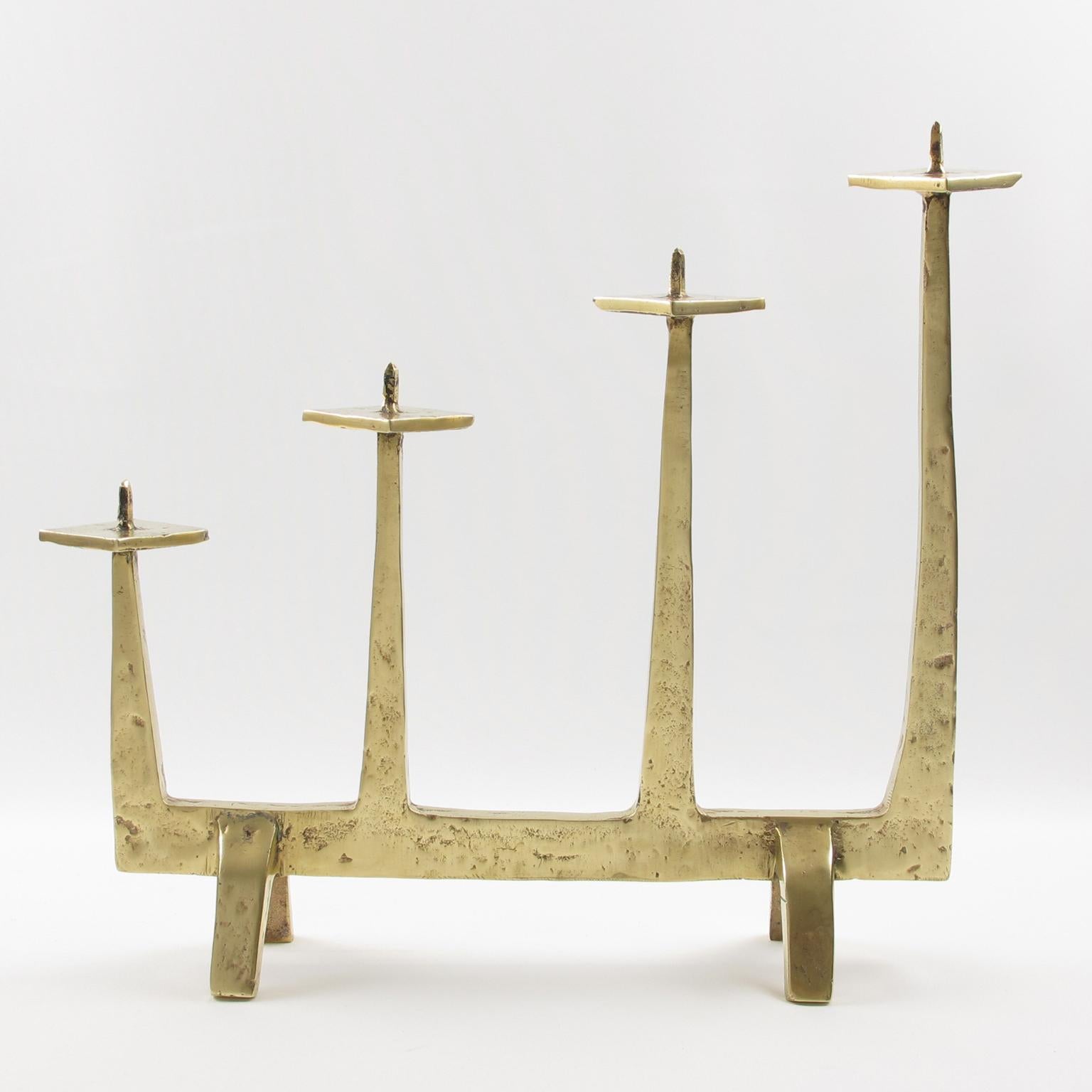 This elegant 1960s modern heavy bronze candlestick, candleholder, or candelabra has a design reminiscent of Felix Agostini's (1919-1980) work. The brutalist design is in a handmade-feel textured pattern with a gilded patina. This piece is highly