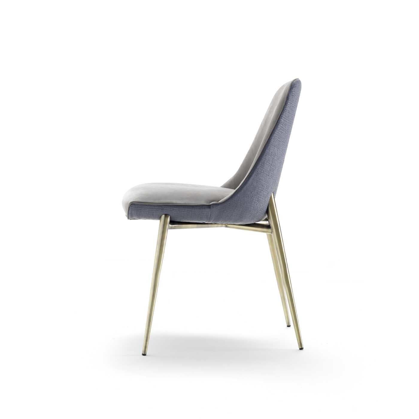 This elegant chair exudes mid-century elegance and a contemporary flair. It will be a stunning addition to a modern dining room or refined study. Its structure is crafted of metal with a satin brass finish and comprises four slanted legs and the
