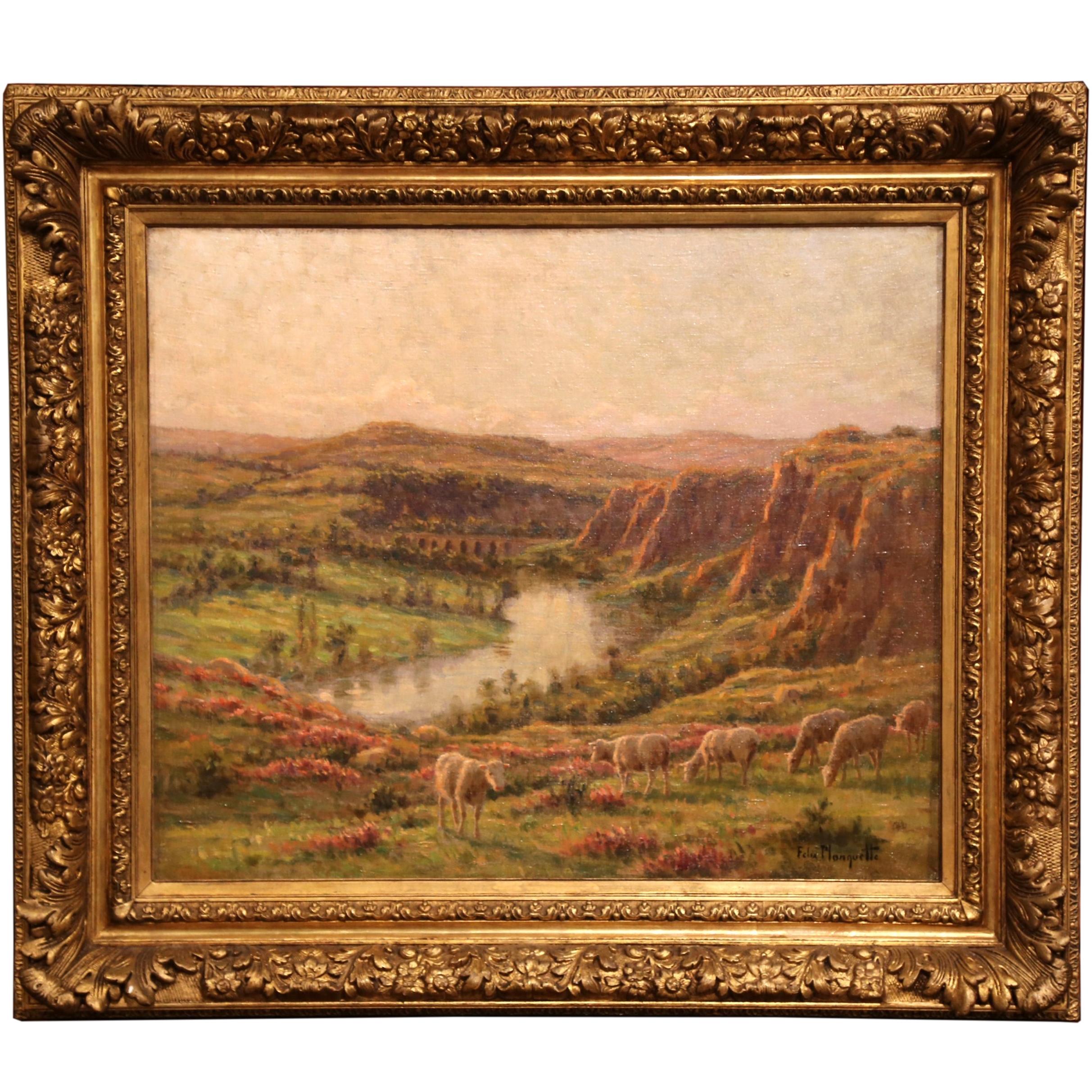 This oil on canvas painting depicts a peaceful pastoral scene. The composition shows a herd of sheep grazing in the foreground and surrounded a landscape with rolling, picturesque hills and pond in the background. The painting is set inside its