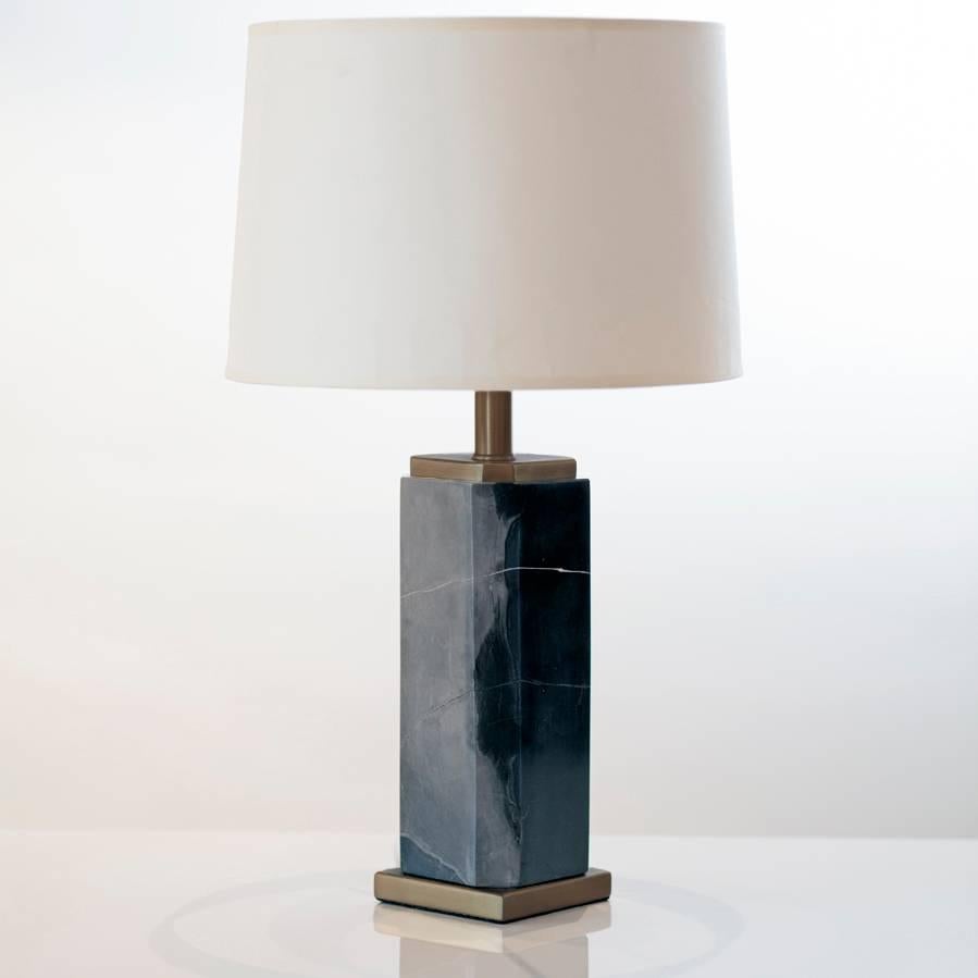 Elegant brass and marble decorative table lamp. The structure of the lamp is made from a black marble with grey veins, the lamp is then finished with a brass plinth on the top and bottom of the lamp. This robust lamp has an attractive weight to it.