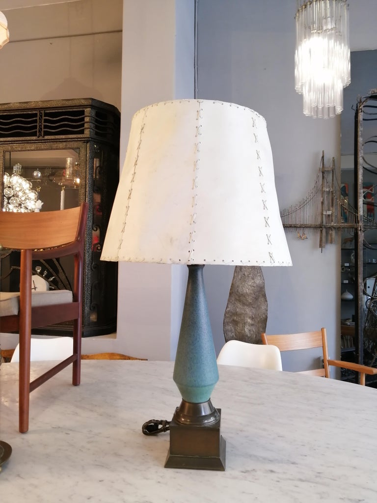 Mexican Mid-Century Modern table lamp by French designer Félix Tissot. The ceramic structure is placed on a brass plinth. The shade is made of parchment paper.