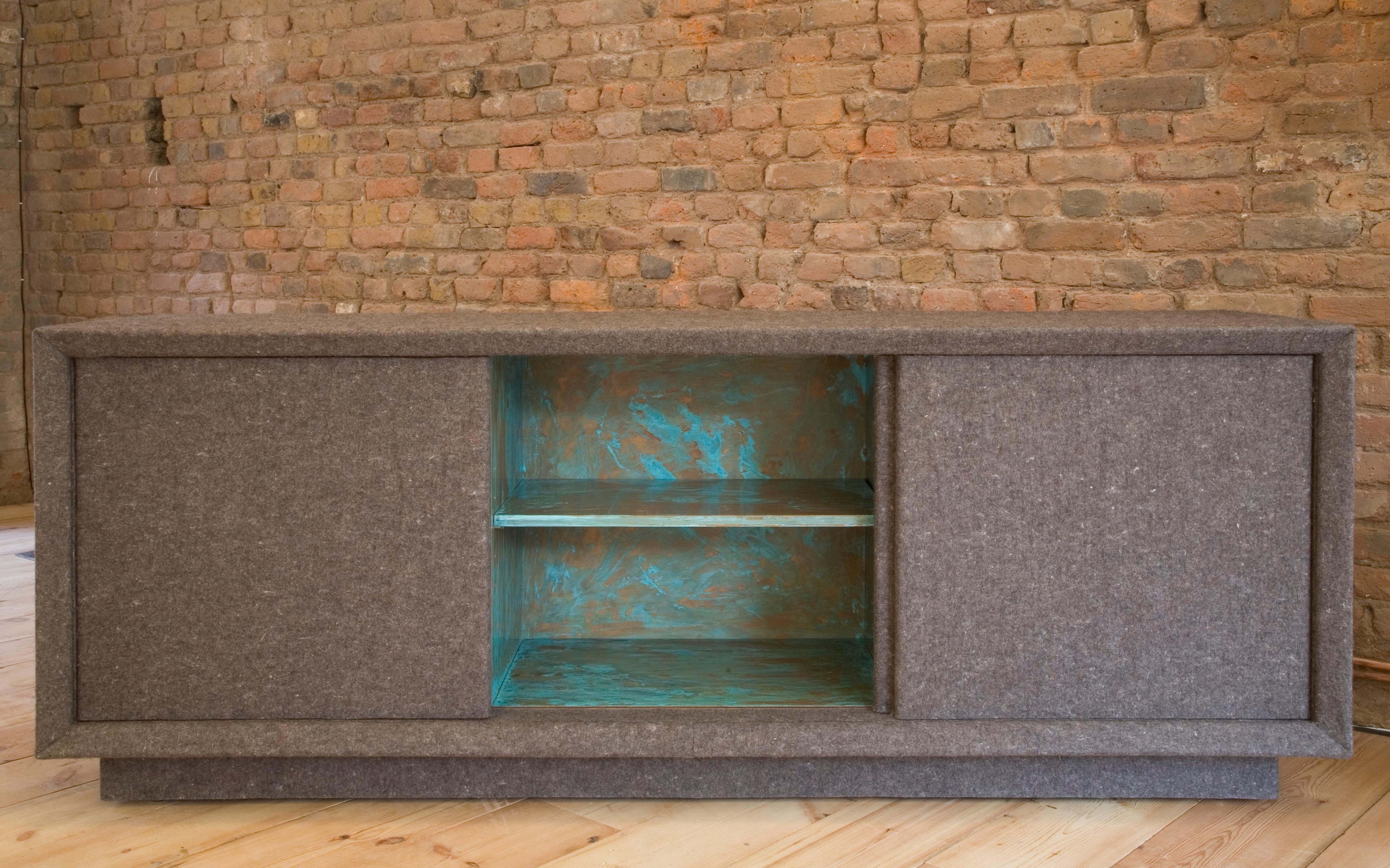 Wrapped in 5mm industrial felt with an interior of walnut, patinated and polished copper with a combination of drawers and adjustable shelving accessed through 3 top hung sliding doors.
This piece is my homage to Joseph Beuys but with more than a