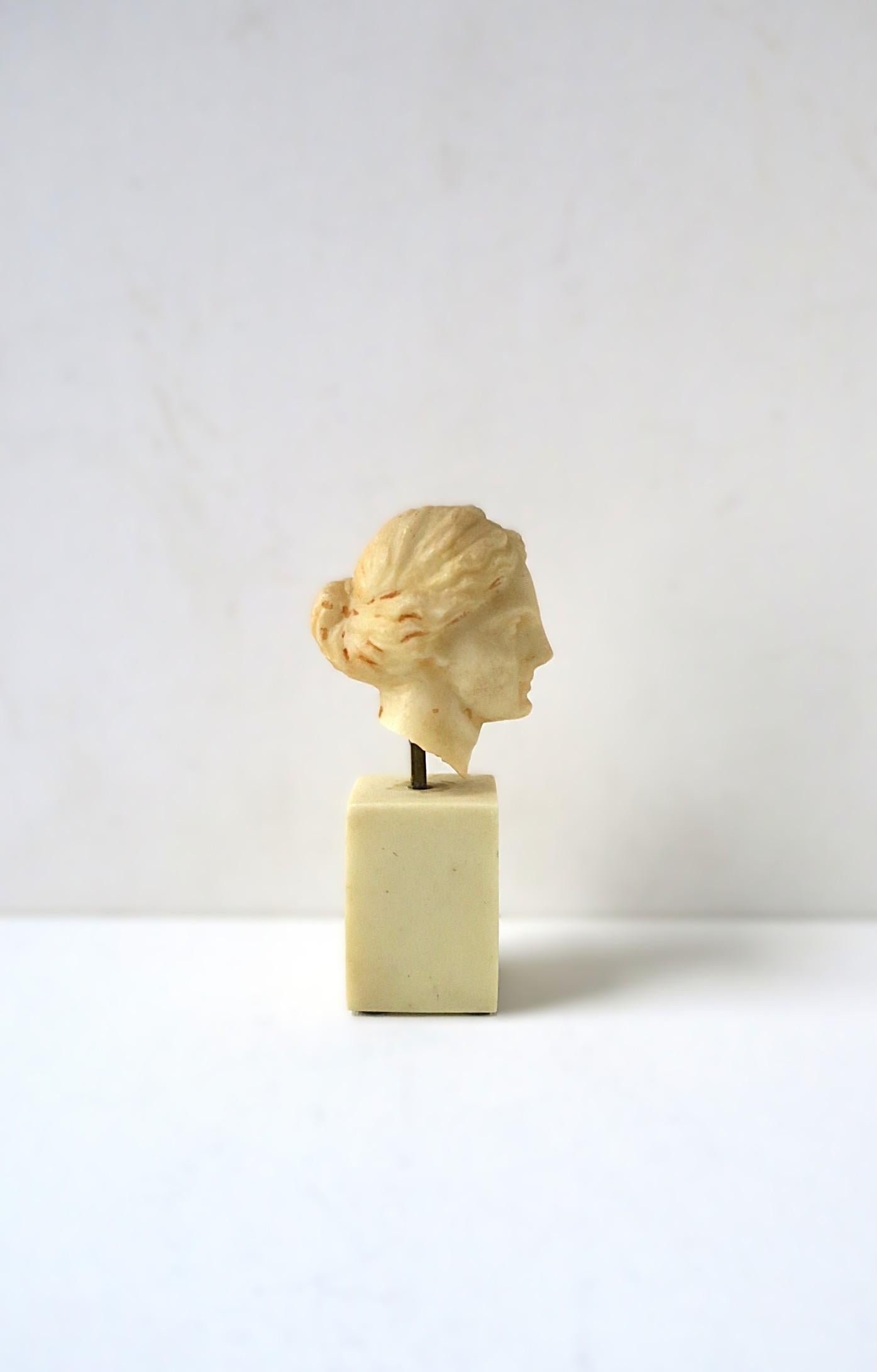 Reproduction d'une sculpture en buste de forme féminine antique représentant la déesse Diane, dans le style gréco-romain, vers la fin du XXe siècle. La statue de buste est construite en résine de marbre faux albâtre, montée avec une tige en laiton