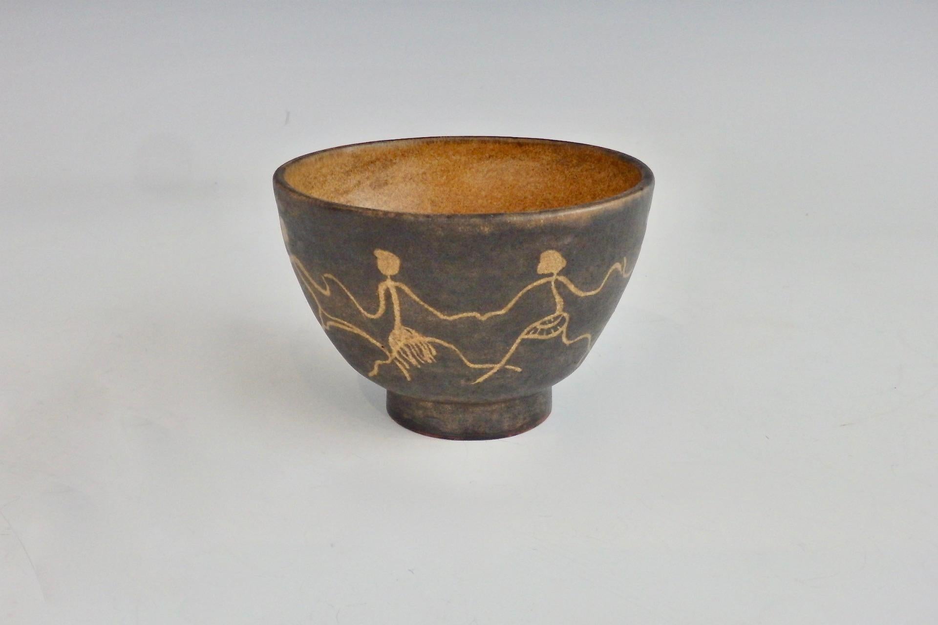 Pottery bowl by Rozsika Blackstone New York and Arizona, circa 1920-1962.
Caramel colored interior, brown exterior, sgraffito decorated with female stick figures holding hands and dancing in a ring, red ware body, incised signature R.B.
