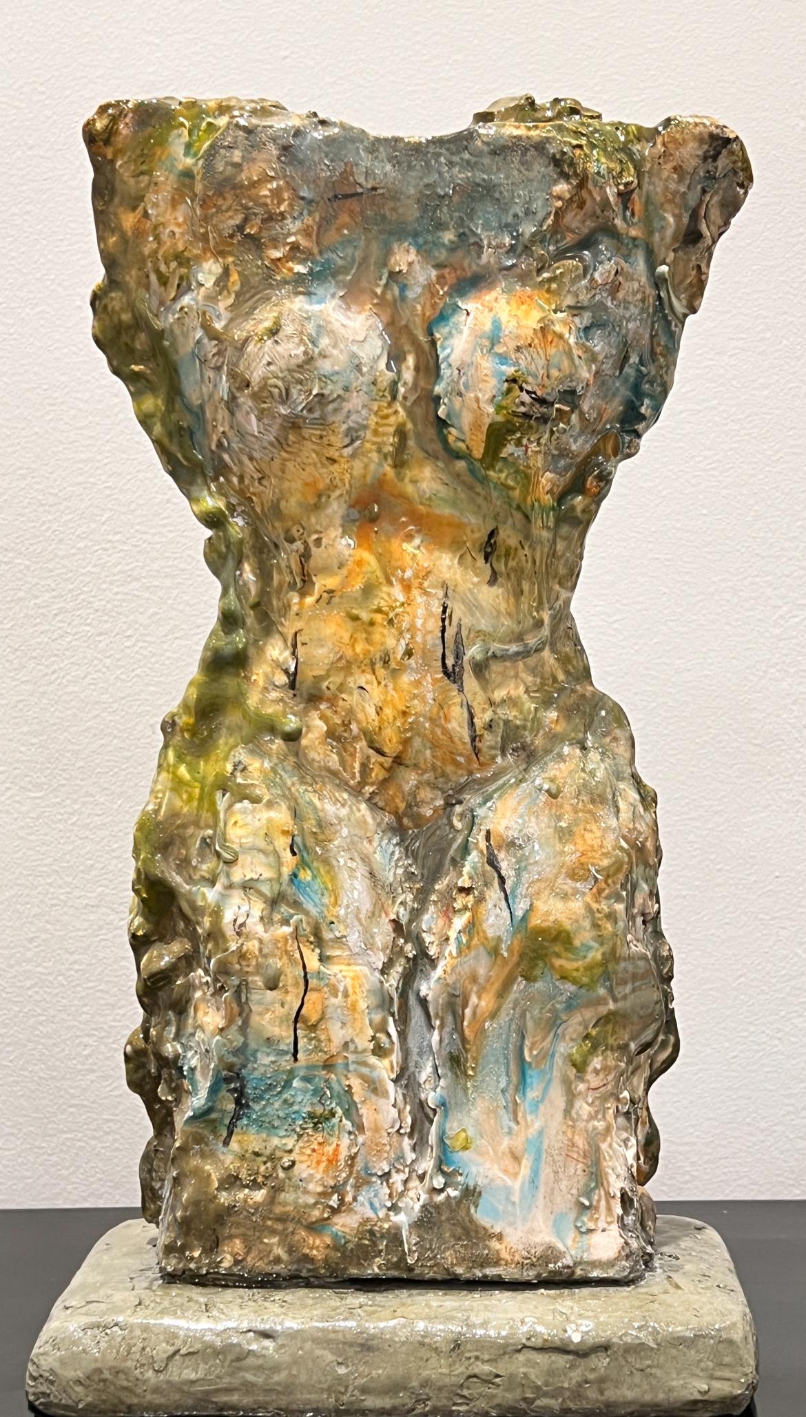A one of a kind sculpture features a female torso, hand crafted from a mixed media to include pigmented scagliola, gypsum, and resin. The multicoloured  sculpture  showcases mossy hues that blend beautifully, creating an artwork with harmonious