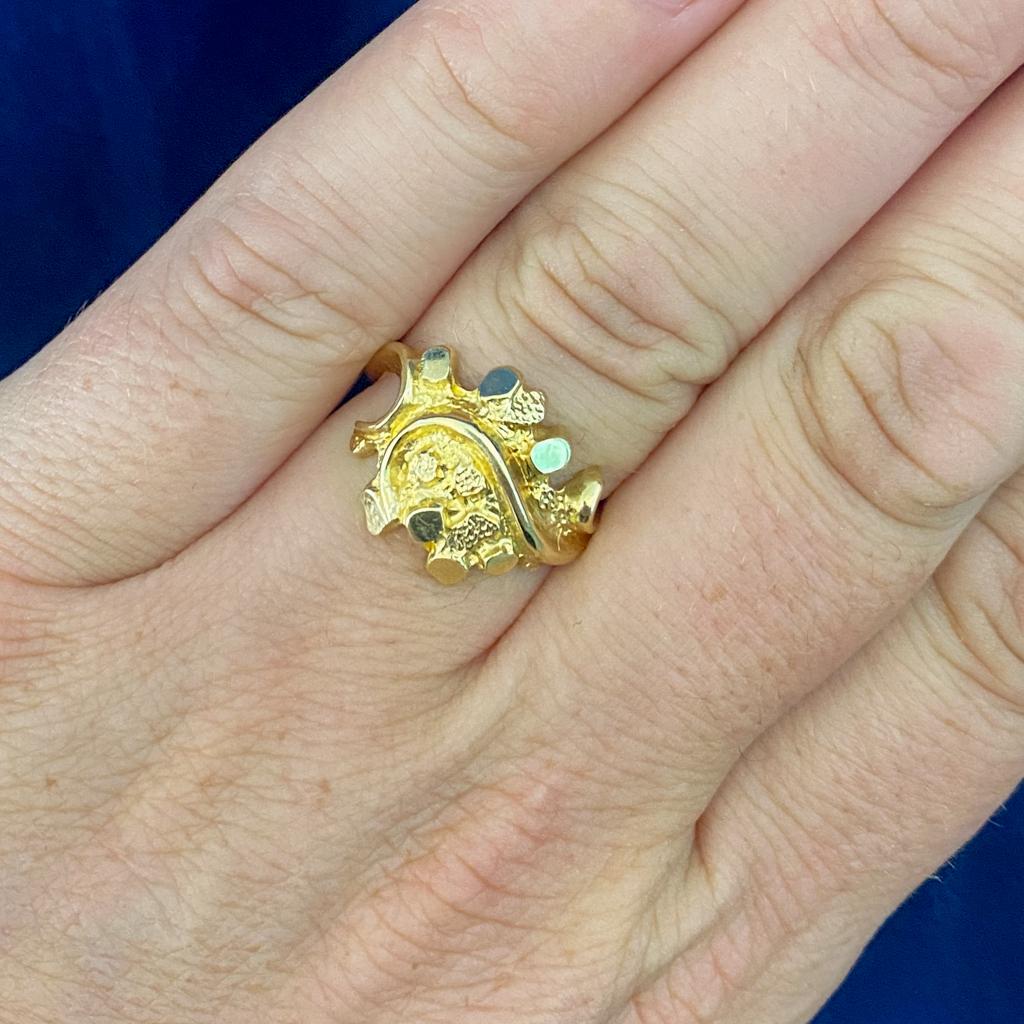 This is a beautiful variation on a classic nugget design! The bold nugget design is gracefully complimented by the swirling design that flows through it and forms the band of the ring. The slender flourish shines brightly as it curves through the