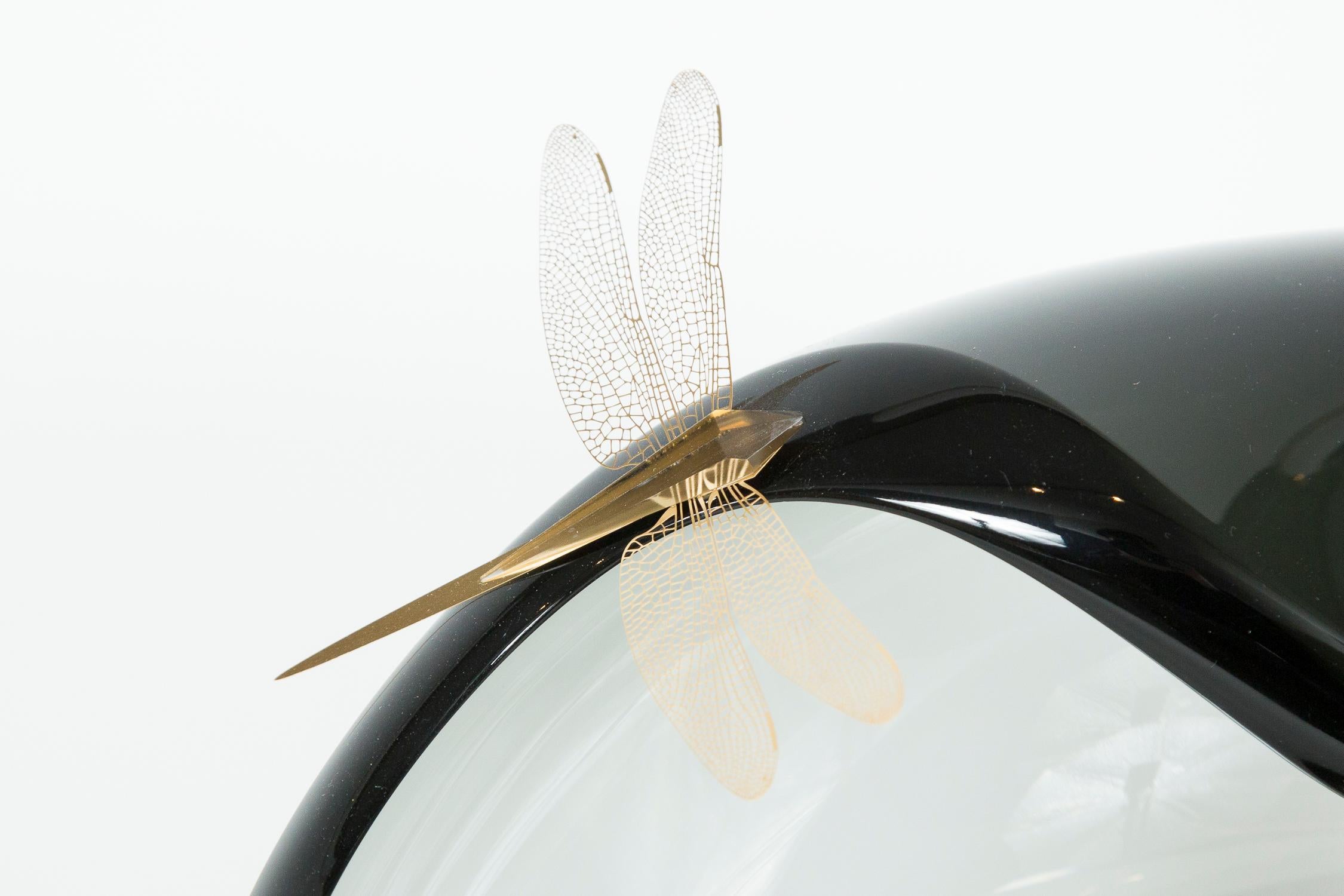 Each dragonfly is made from laser cut sheet steel which has been gold plated and adorned with a cut glass abdomen. The steel is thin enough to allow the wings to flutter. 

With infinite fascination for her chosen medium glass, Enemark's work