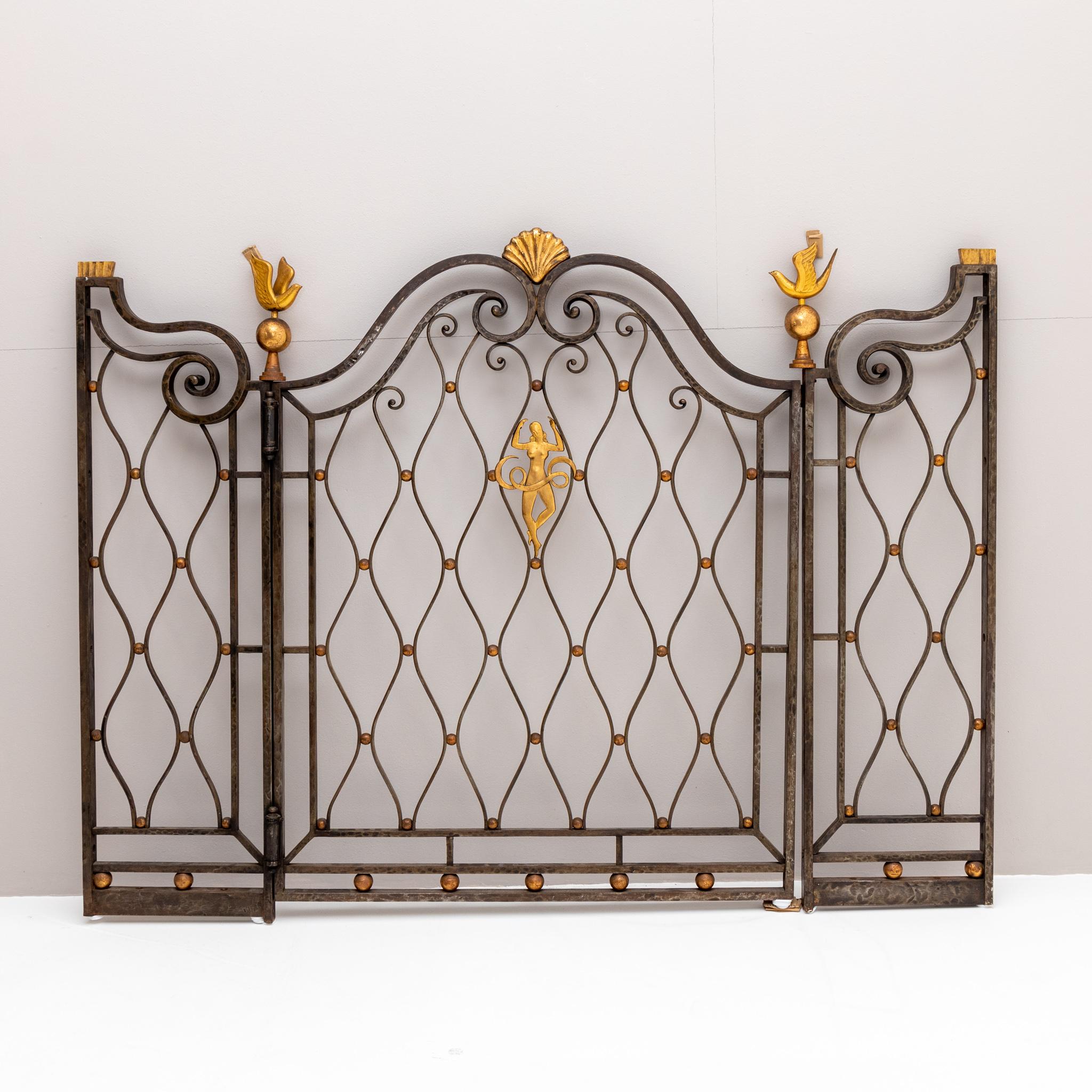 Fence element with gold patinated decors in the form of doves, shells, and a central female figure. For comparable pieces see Lit.: Francois Baudot: Gilbert Poillerat maitre ferronnier. Paris 1992, p. 238f.