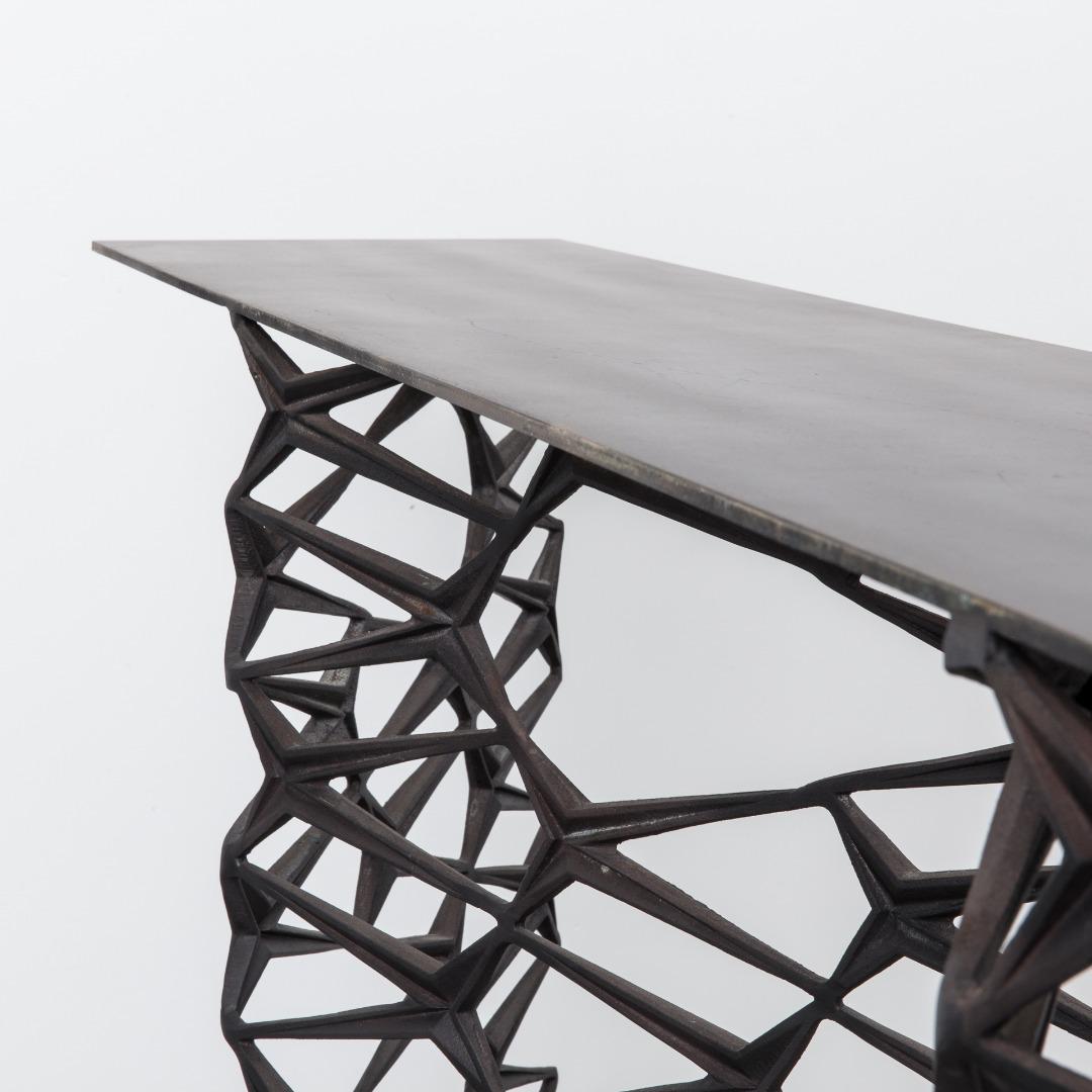 The Fenced-In console is distinguished by its intricately patterned base inspired by the ornate ironwork found on Brooklyn brownstones. Made from powder coated aluminum, the console has a sleek surface that sits atop its bold base. This piece is
