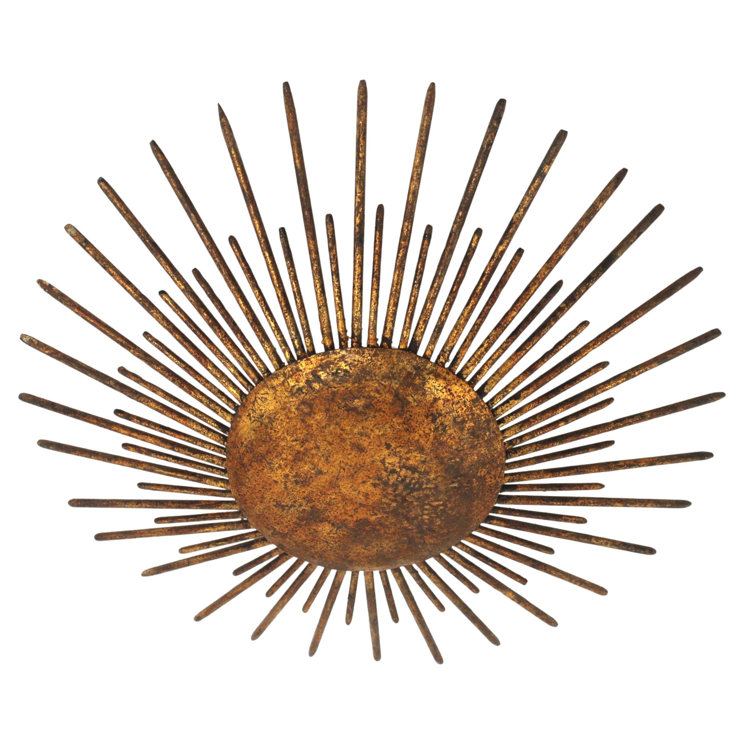 French Modern Neoclassical Sunburst Light Fixture with Spikes Detail,  France, 1940s
This stunning hand-hammered gilt iron sunburst ceiling light was manufactured at the Art Deco Period. It has accents in transition to Brutalist style. 
A sunburst