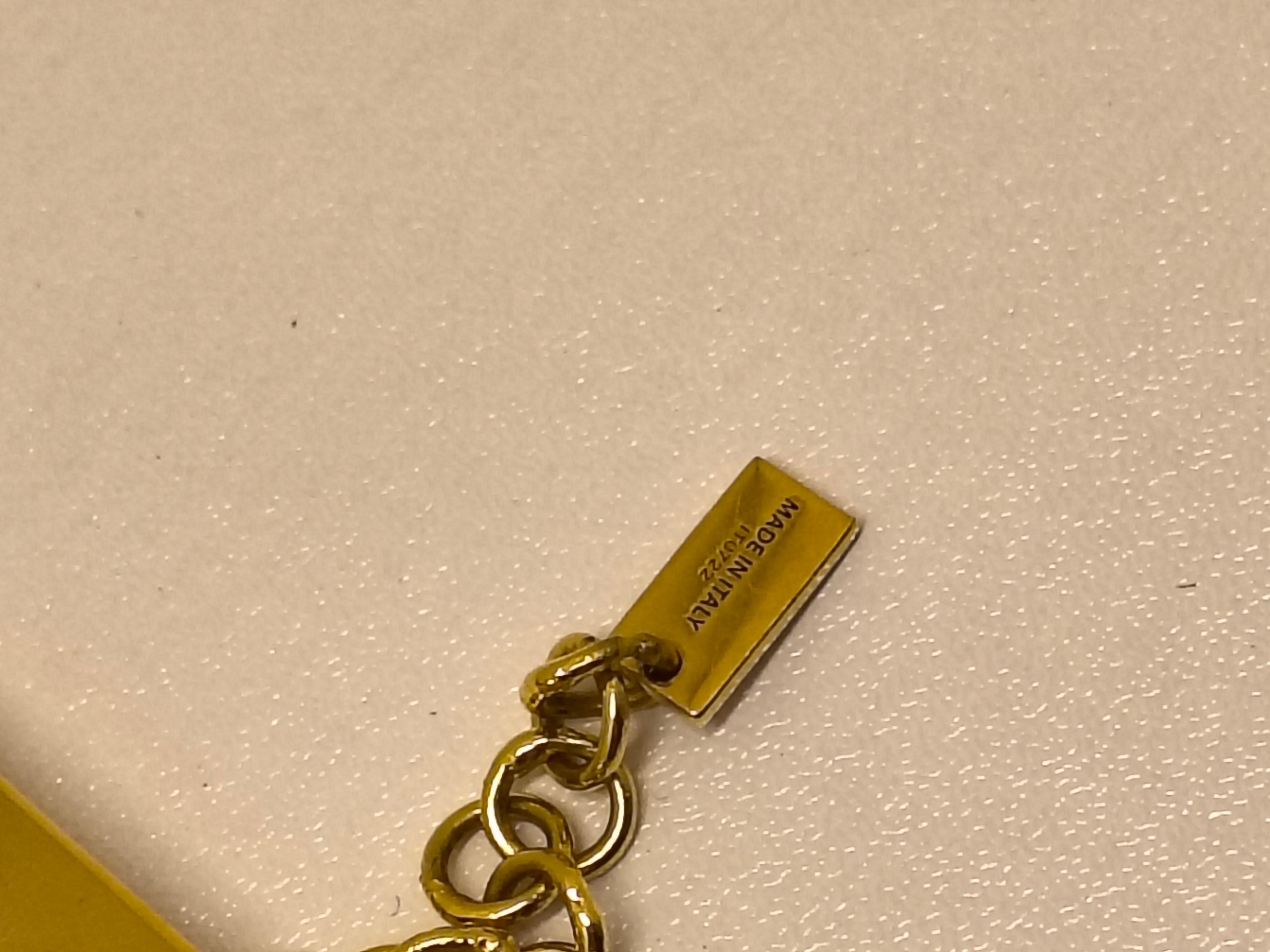 Ti presentiamo il Bracciale Largo Zucca di Fendace, un accessorio di grande impatto che unisce gli iconici design di Fendi e Versace. Questo braccialetto sfoggia la rinomata stampa Zucca, con i loghi F intrecciati che rappresentano l'eredità e la