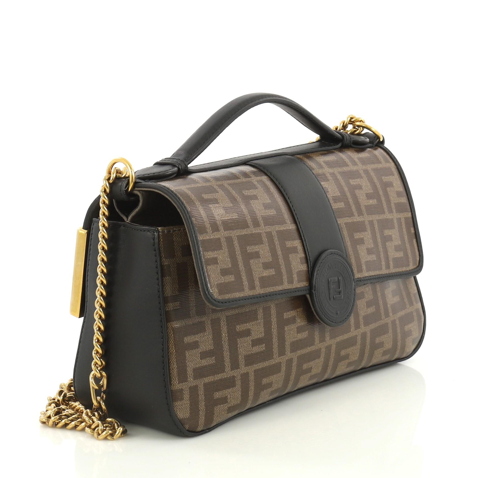 This Fendi 1974 Double F Flap Bag Zucca Coated Canvas and Leather Medium, crafted from black and brown zucca coated canvas and leather, features chain link strap, top handle, exterior back flap compartment, and gold-tone hardware. Its magnetic