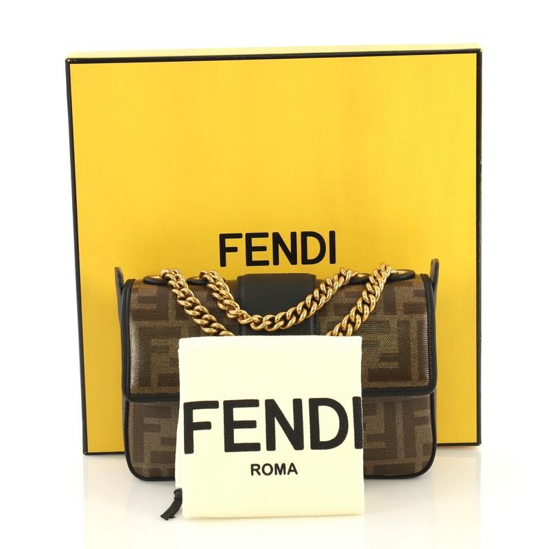This Fendi 1974 Double F Flap Bag Zucca Coated Canvas Mini, crafted from brown zucca coated canvas and black leather, features chain link strap, leather trim, leather Fendi medallion, and gold-tone hardware. Its flap with magnetic snap closure opens