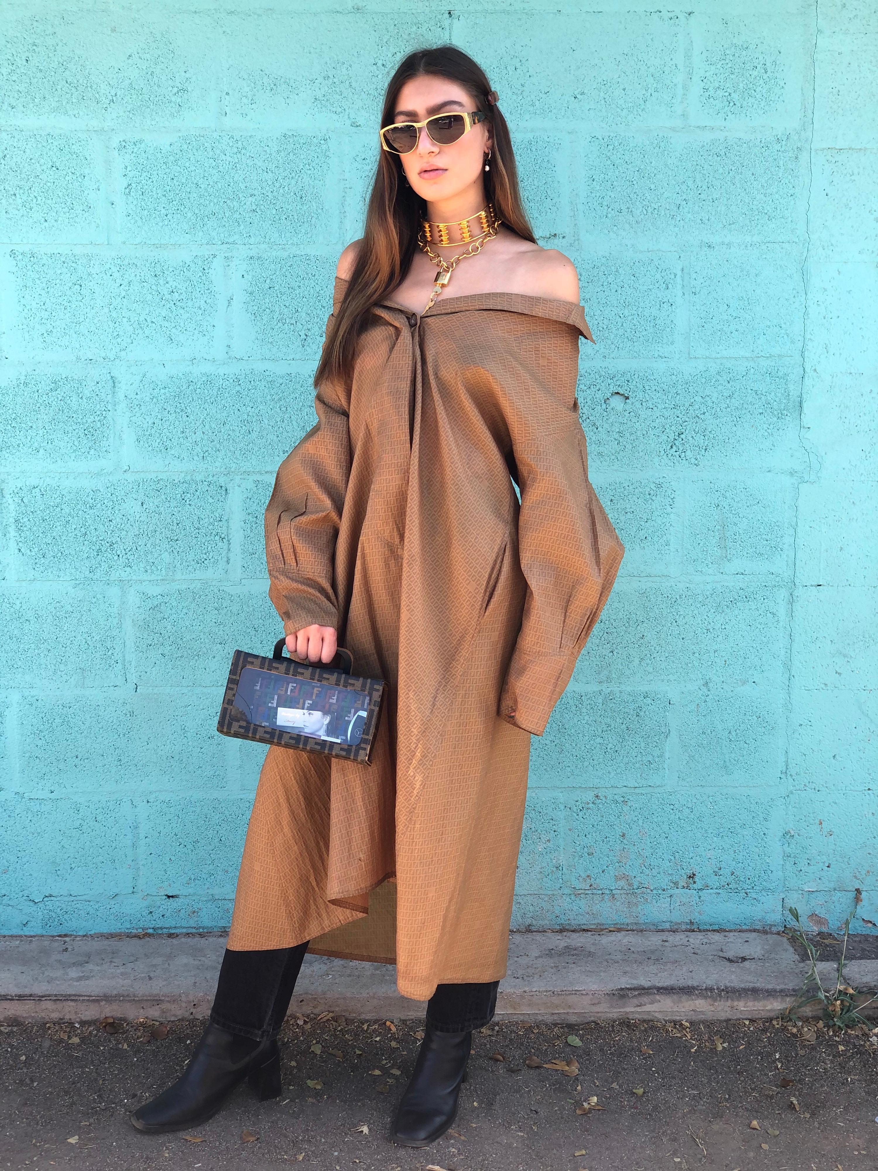Zoom in and Elevate all your fall/winter looks with this amazing trench! Circa 1980s from Fendi's 365 line, this trench coat is a gorgeous camel color and features the Fendi monogram printed all over with billowy sleeves. Includes large hidden