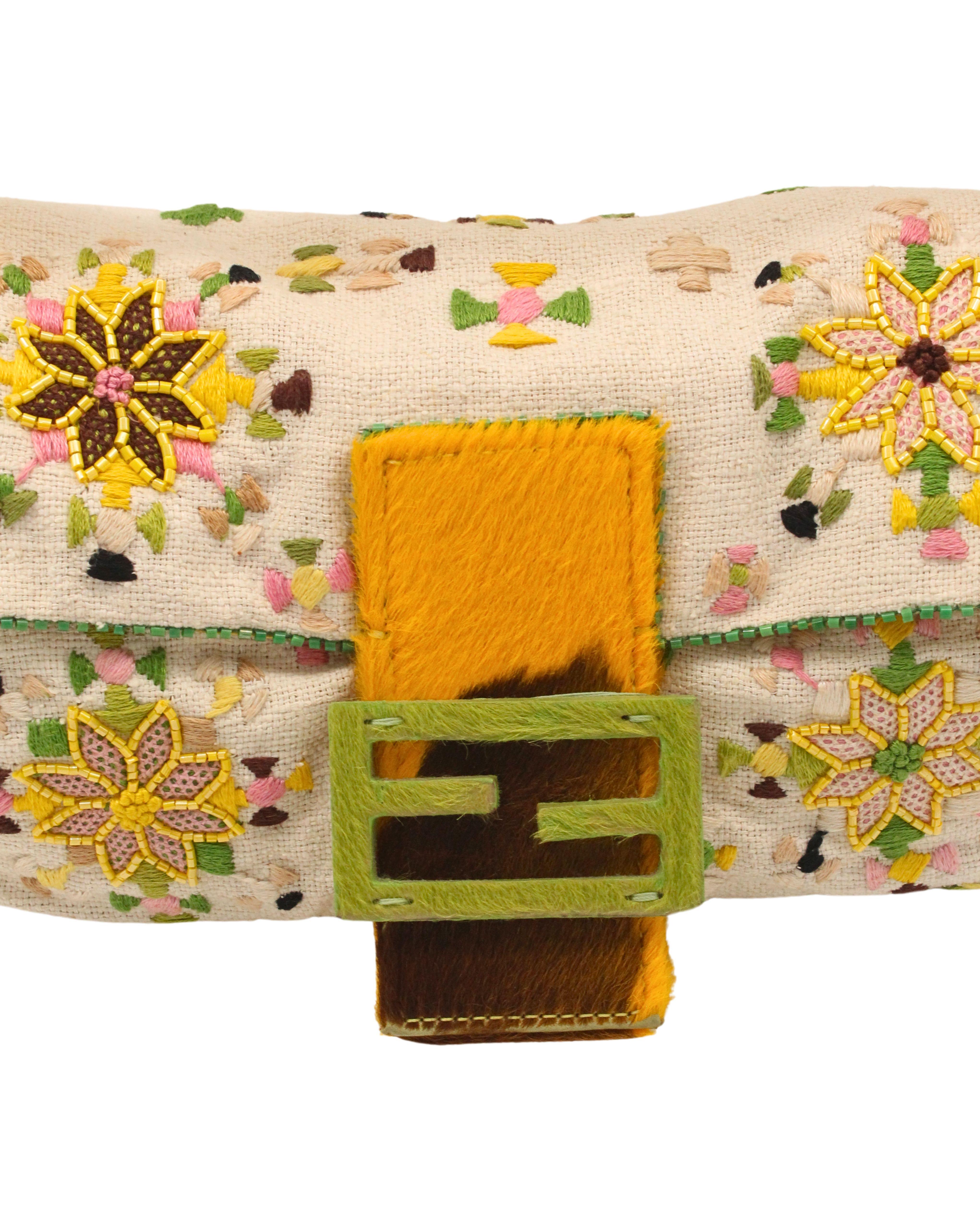 Datant des années 90, ce sac baguette Fendi en édition limitée est réalisé en toile de soie tissée crème, avec un motif floral brodé et perlé coloré et des bordures perlées vertes. Il est doté d'une bandoulière et d'un rabat jaune acide et marron,