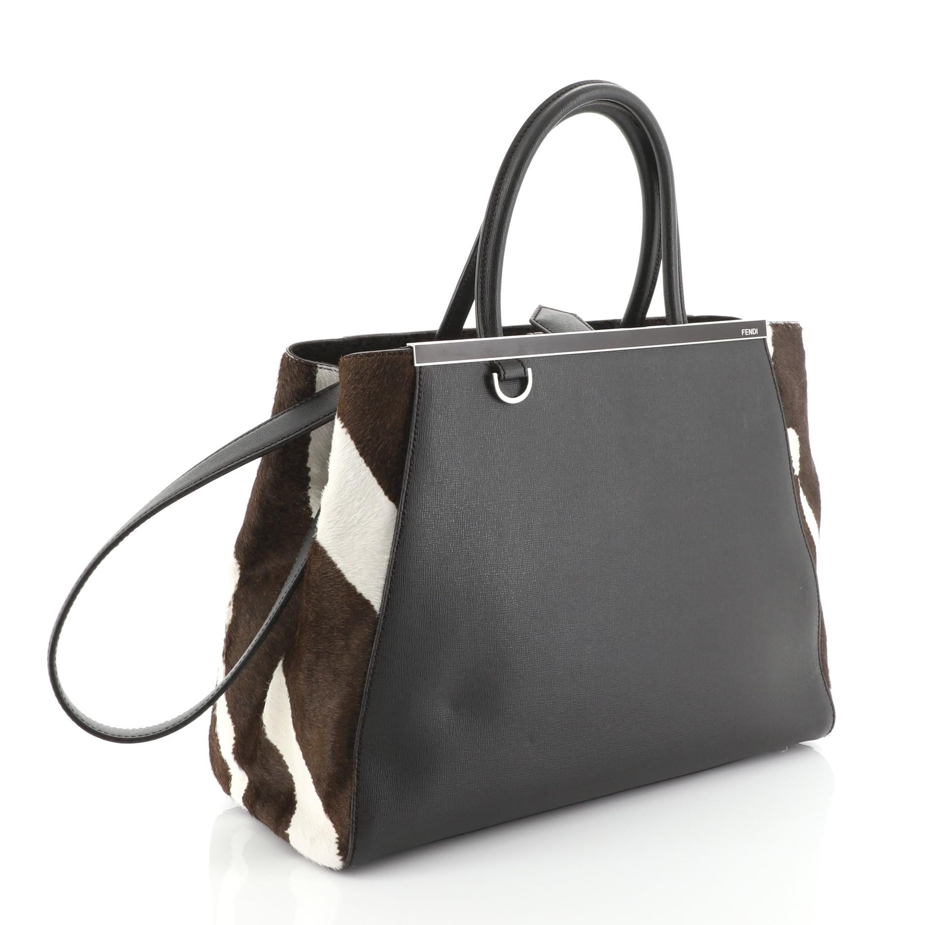 This Fendi 2Jours Bag Pony Hair and Leather Large, crafted in brown leather and brown pony hair, features a top bar with the Fendi brand name, dual rolled leather handles, and silver-tone hardware. Its snap button closure opens to brown fabric