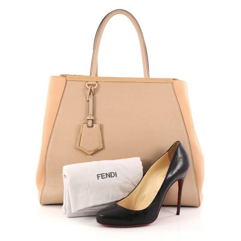 This authentic Fendi 2Jours Handbag Leather Large is impeccably stylish with a simple silhouette and structured design. Finely crafted in sturdy peach and nude leather, this popular tote features a shining top bar that dons the Fendi brand name,