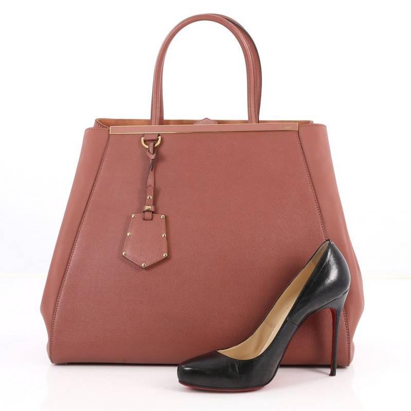 This authentic Fendi 2Jours Handbag Leather Large is an impeccably stylish bag perfect for your everyday looks. Crafted in mauve leather, this popular tote features dual-rolled leather handles, a shining top bar that dons the Fendi brand name,