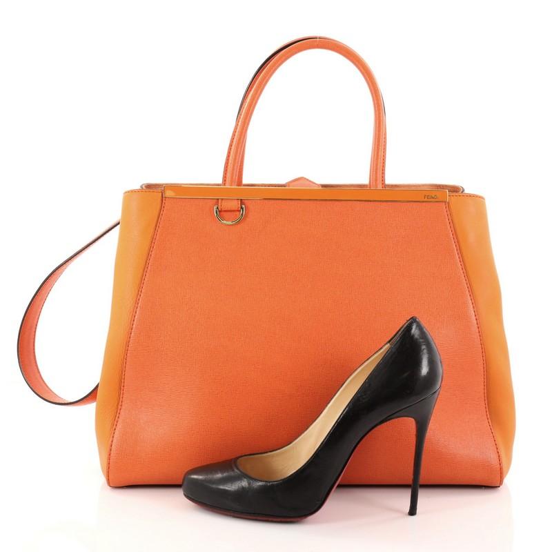 This authentic Fendi 2Jours Handbag Leather Medium is impeccably stylish with a simple silhouette and structured design. Finely crafted in sturdy orange leather with soft calfskin sides, this popular tote features a shining top bar that dons the
