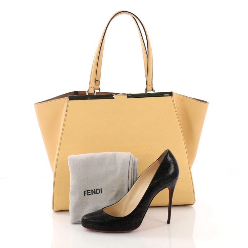 This Fendi 3Jours Handbag Leather Large, crafted in yellow leather, features a shining split top bar that dons the Fendi brand name, tall leather handles, expandable side wings, and silver-tone hardware. Its magnetic snap closure opens to a brown