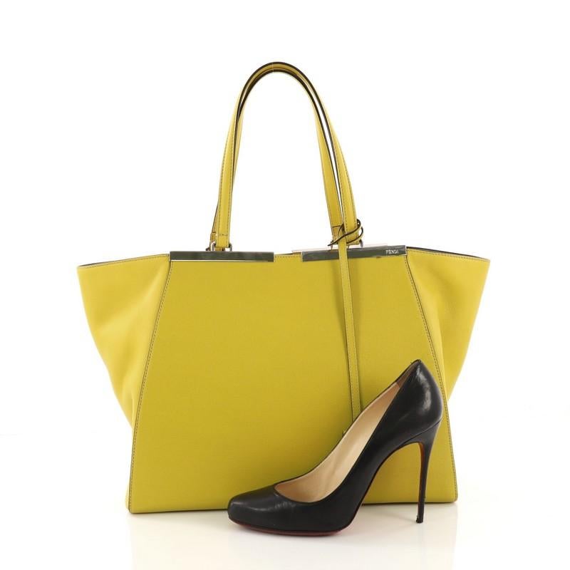 This Fendi 3Jours Handbag Leather Large, crafted in yellow leather, features a shining split top bar that dons the Fendi brand name, tall leather handles, expandable side wings, and silver-tone hardware. Its magnetic snap closure opens to a gray