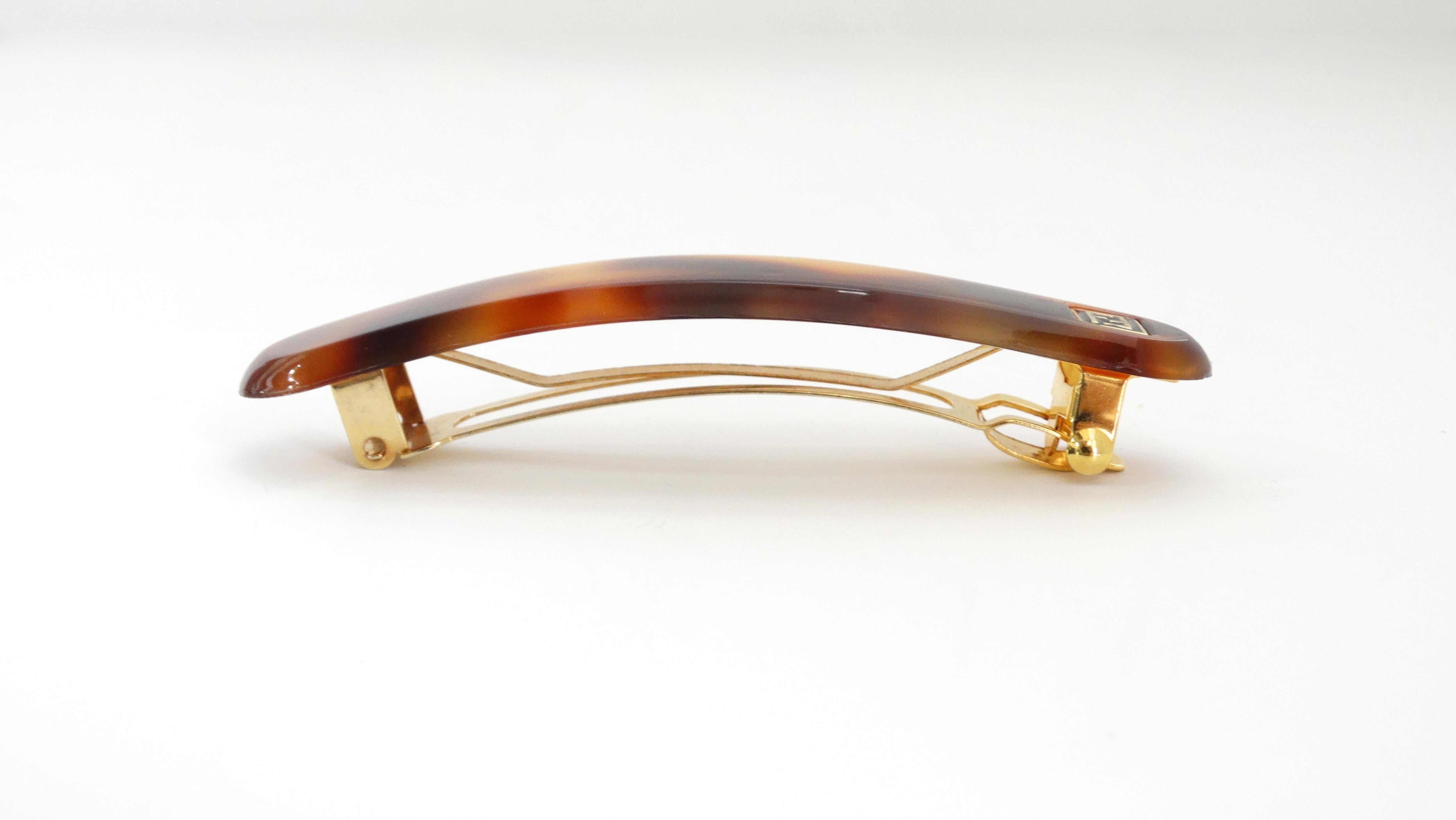 Spice up your hair styles with this adorable Fendi barrette! Circa 1980s, this barrette is made out of acrylic and is finished in brown tortoise shell. Features the Fendi logo and a clasp closure stamped with Fendi. Subtle and an easy everyday